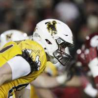 Why did Utah football agree to play a game at Wyoming?