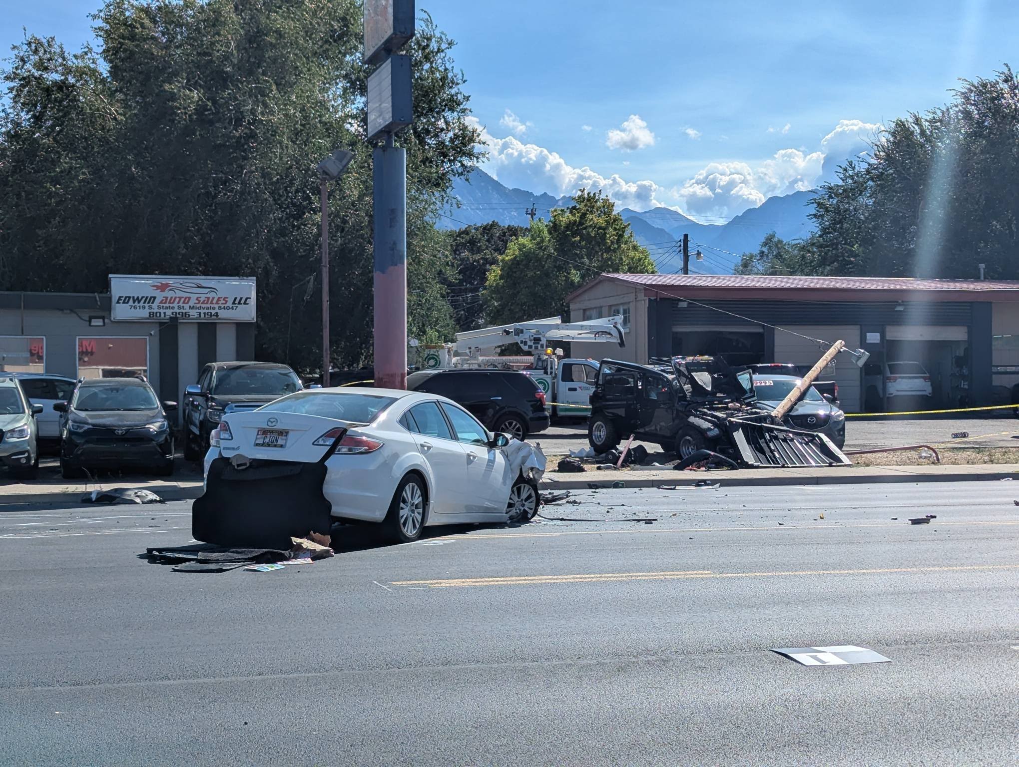 Crews work at the scene of a car crash at 7651 S. State Street in Midvale on Monday. The collision killed a pedestrian and critically injured two drivers, police said.