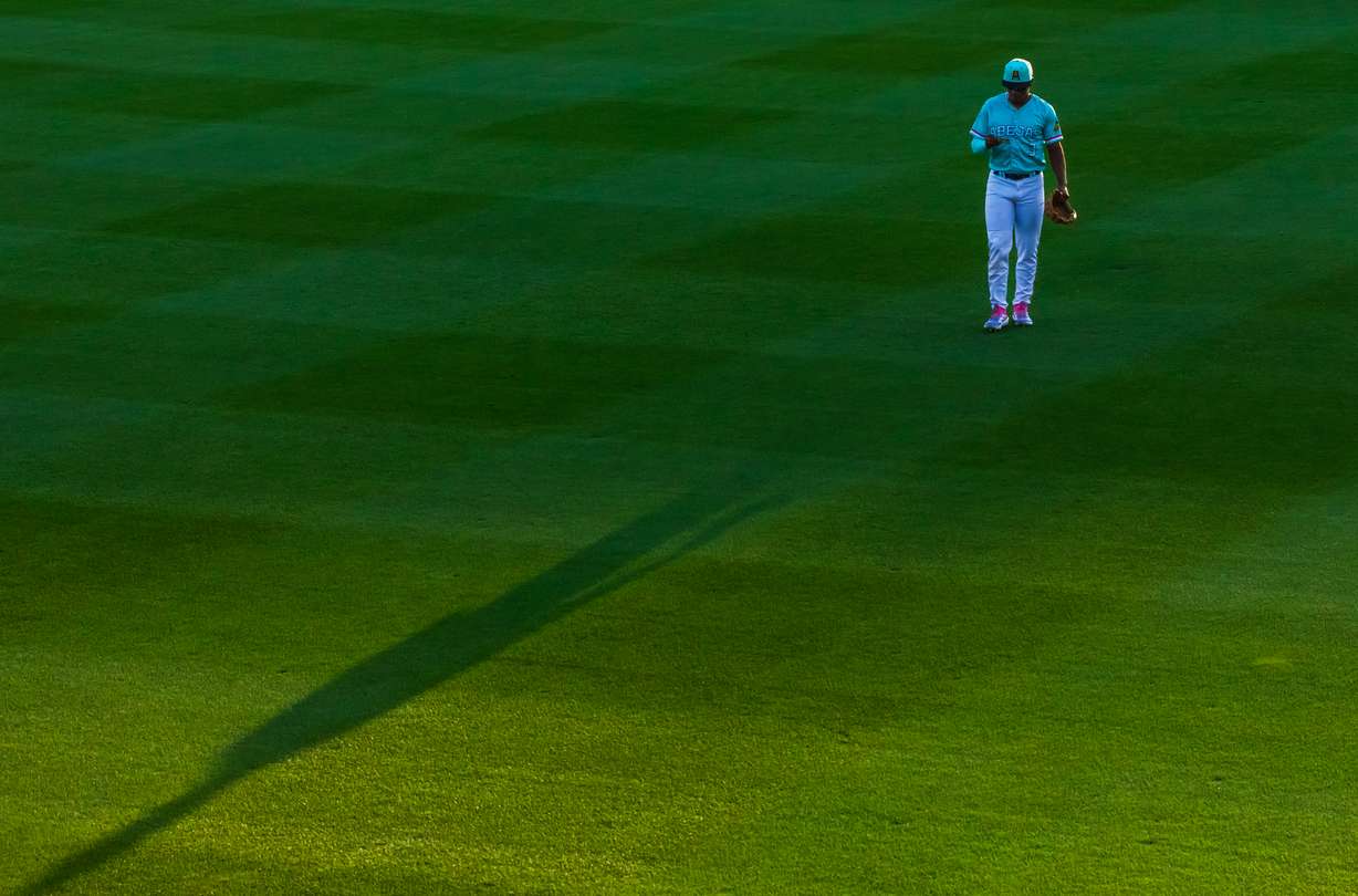 Salt Lake Bees outfielder Nelson Rada reads a defensive scouting report while in the outfield during a game between the Bees and El Paso Chihuahuas at The Ballpark at America First Square in South Jordan on Saturday, Sept. 6, 2025.