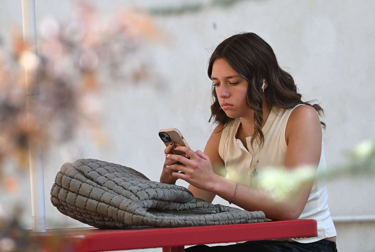 University of Utah student McKenna Peterson looks at her phone outside the bookstore in Salt Lake City on Friday, Sept. 5.