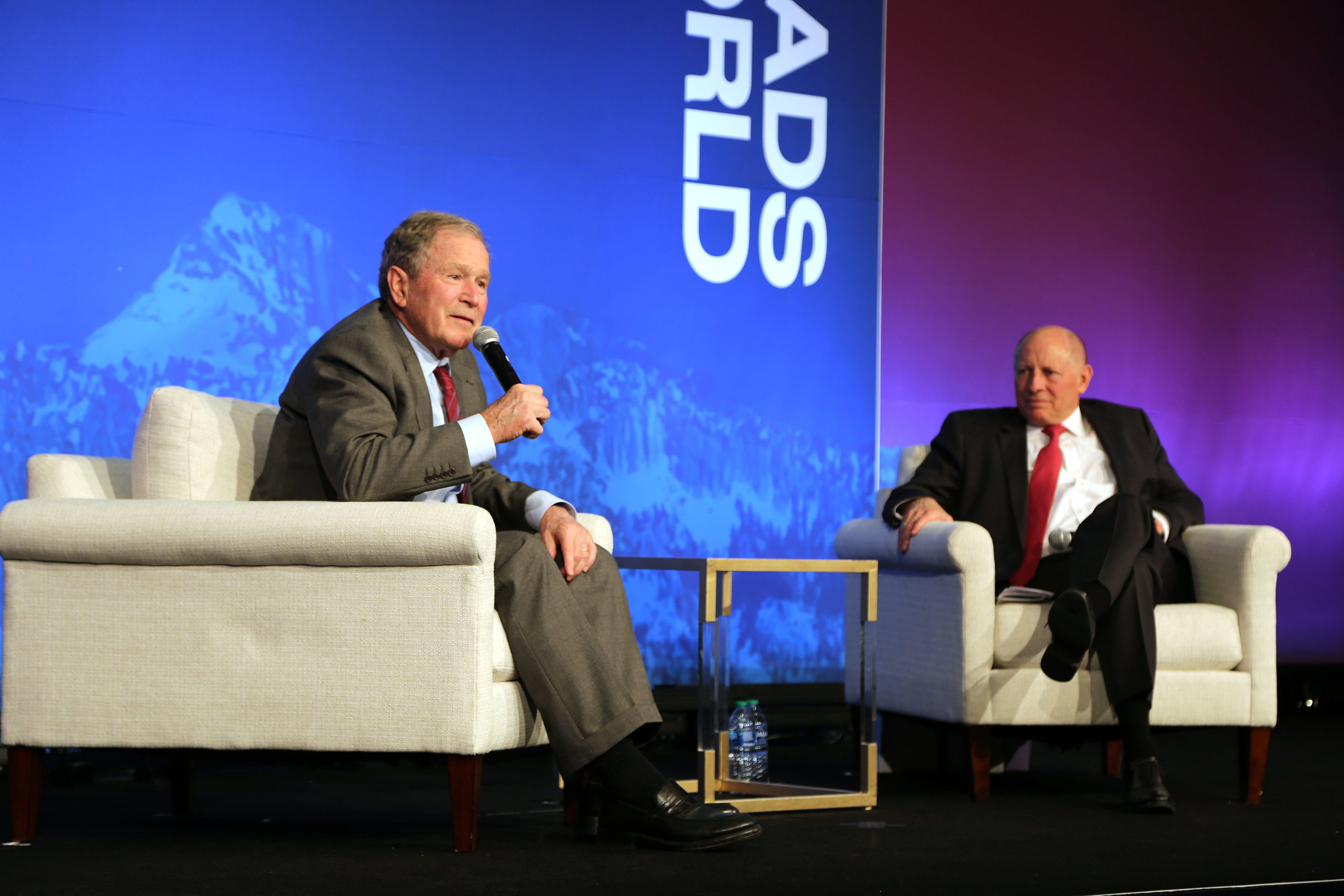 President George W. Bush, left, speaks at Crossroads of the World International Trade Summit at the Grand America Hotel in Salt Lake City on May 23, 2024. At right, Zions Bancorporation Chairman and CEO Harris Simmons listens.