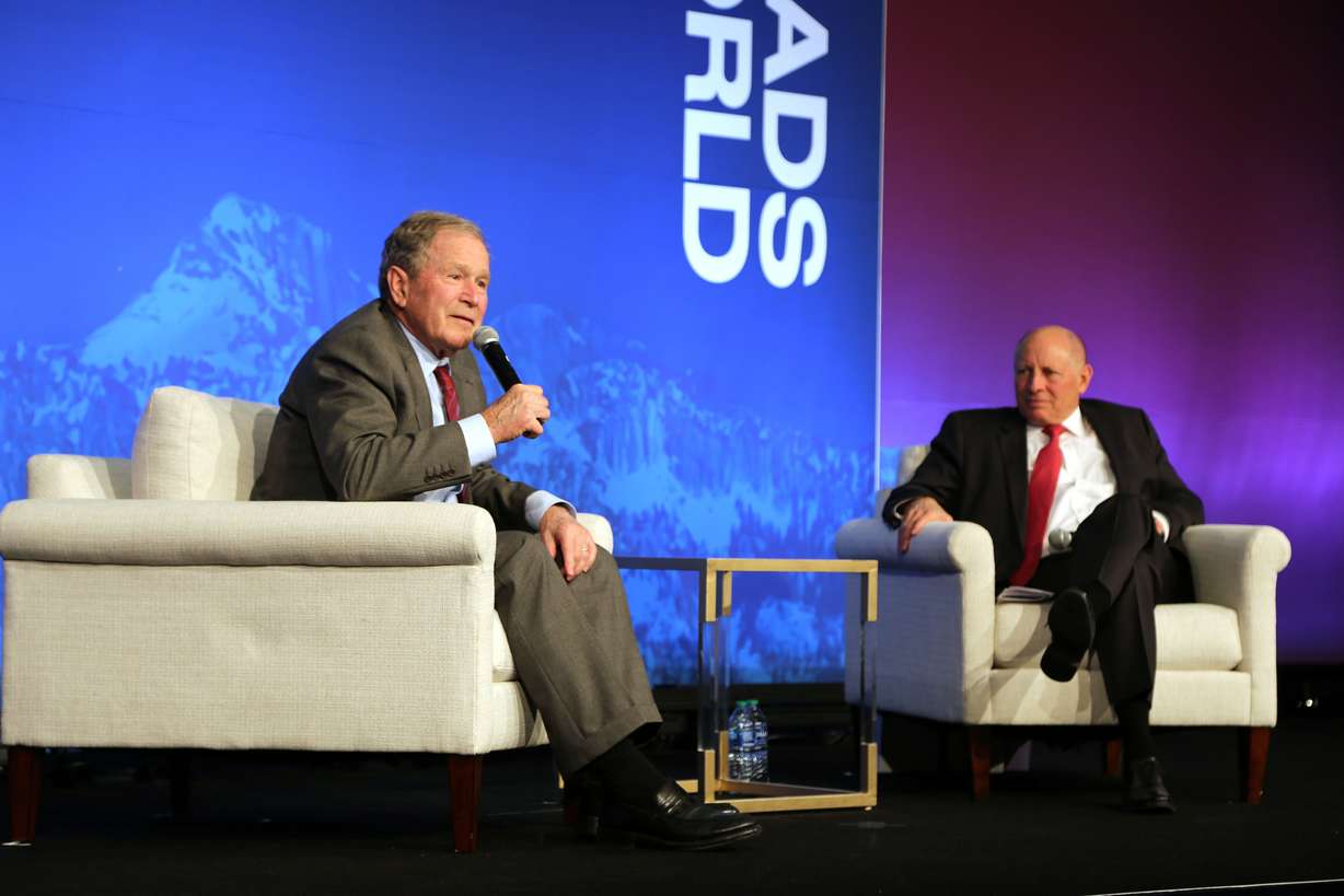 President George W. Bush, left, speaks at Crossroads of the World International Trade Summit at the Grand America Hotel in Salt Lake City on May 23, 2024. At right, Zions Bancorporation Chairman and CEO Harris Simmons listens.