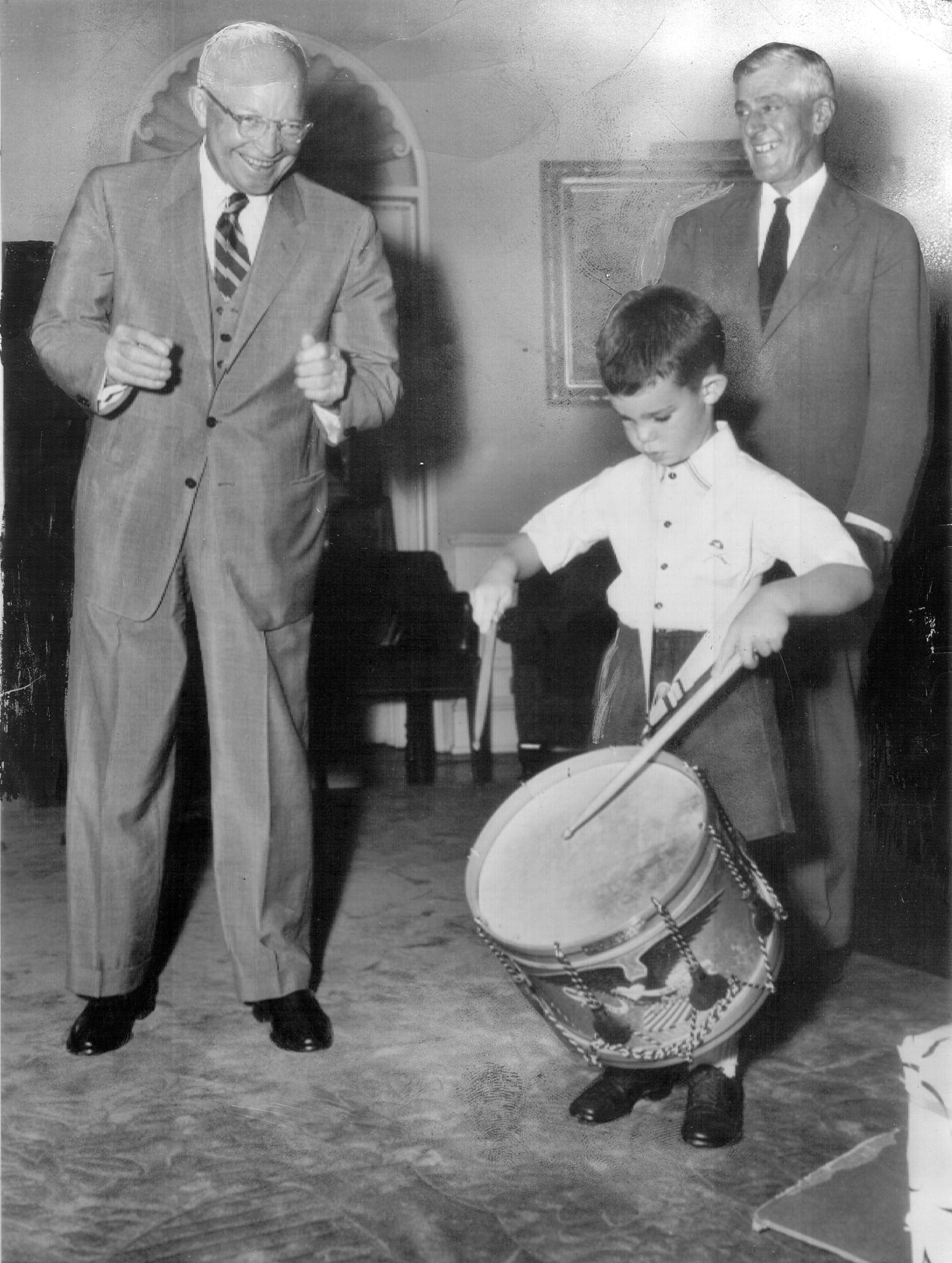 President Dwight D. Eisenhower watches his 6-year-old grandson, David, beat a military drum that was presented to him at the White House in 1954.