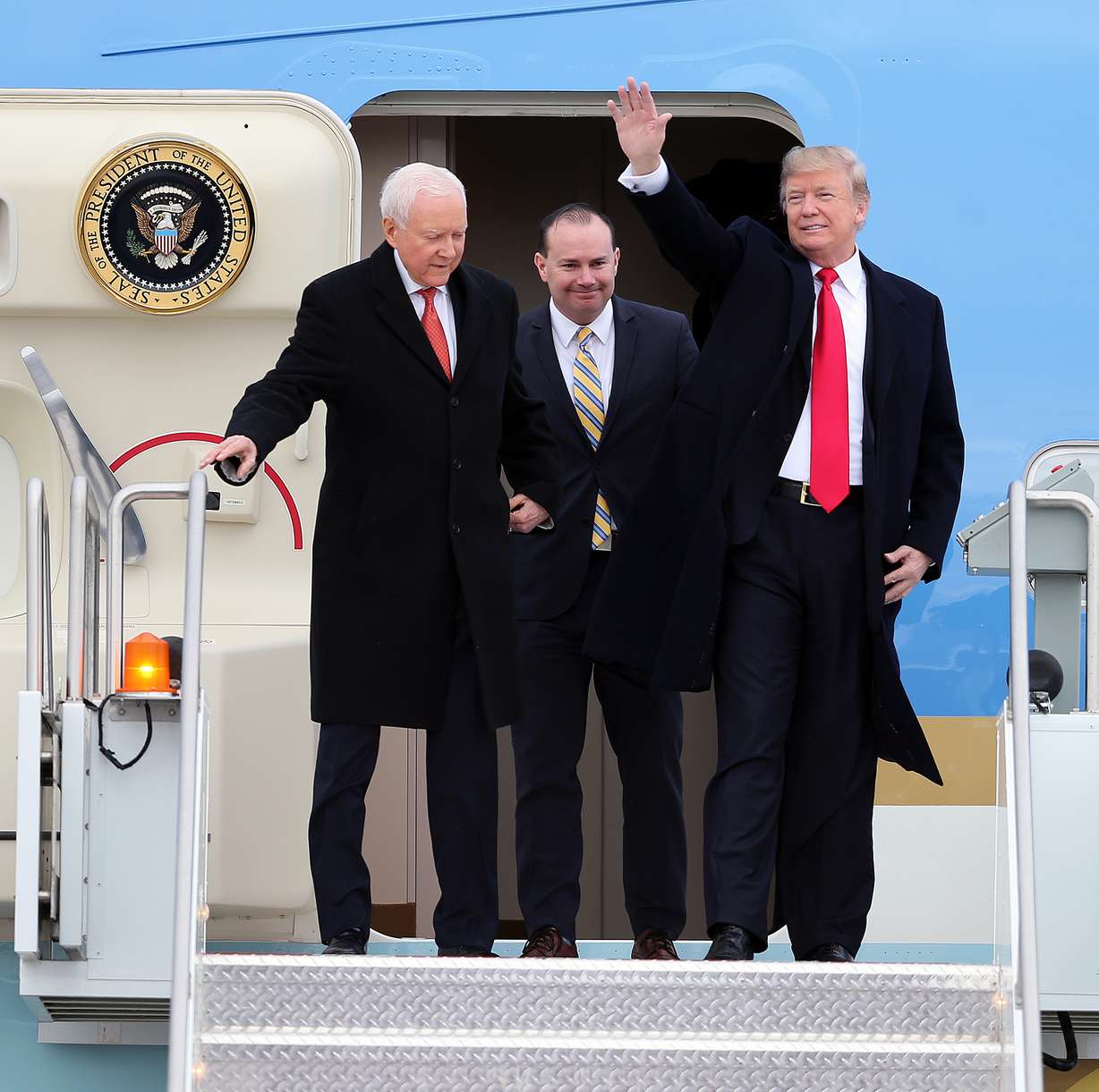 President Donald Trump waves to the crowd as he and Utah Sens. Orrin Hatch and Mike Lee arrive at Roland R. Wright Air National Guard Base at the Salt Lake City International Airport in Salt Lake City on Dec. 4, 2017.