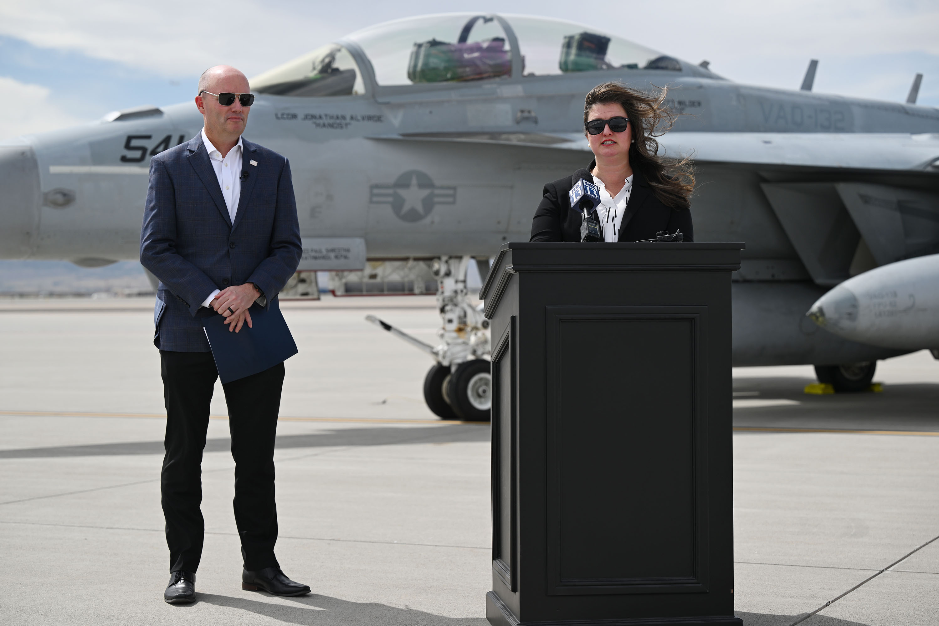 Lauren Barnes, of L3Harris Broadband Communications Systems, and Gov. Spencer Cox at the Utah Air National Guard air base in Salt Lake City on Tuesday, announcing a nearly $600 million contract awarded by the U.S. Navy.