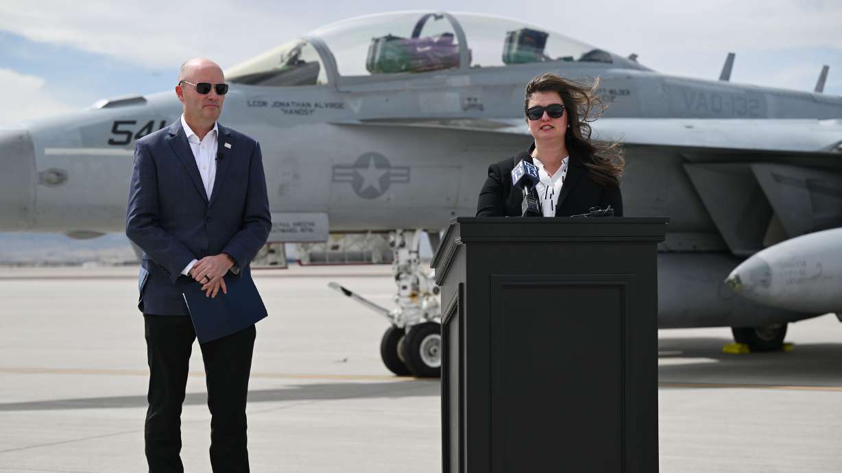 Lauren Barnes, of L3Harris Broadband Communications Systems, and Gov. Spencer Cox at the Utah Air National Guard air base in Salt Lake City on Tuesday, announcing a nearly $600 million contract awarded by the U.S. Navy.