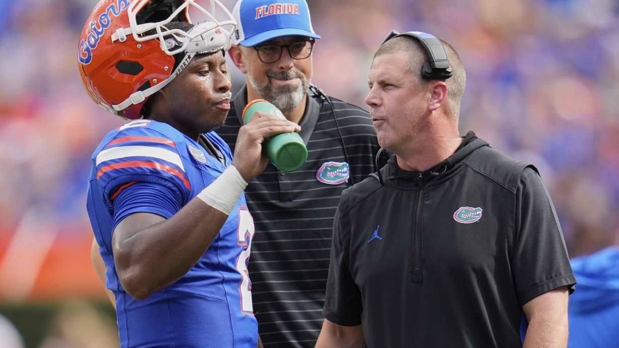 Florida head coach Billy Napier, right, talks with quarterback DJ Lagway during time out in the first half of an NCAA college football game against South Florida, Saturday, Sept. 6, 2025, in Gainesville, Fla.