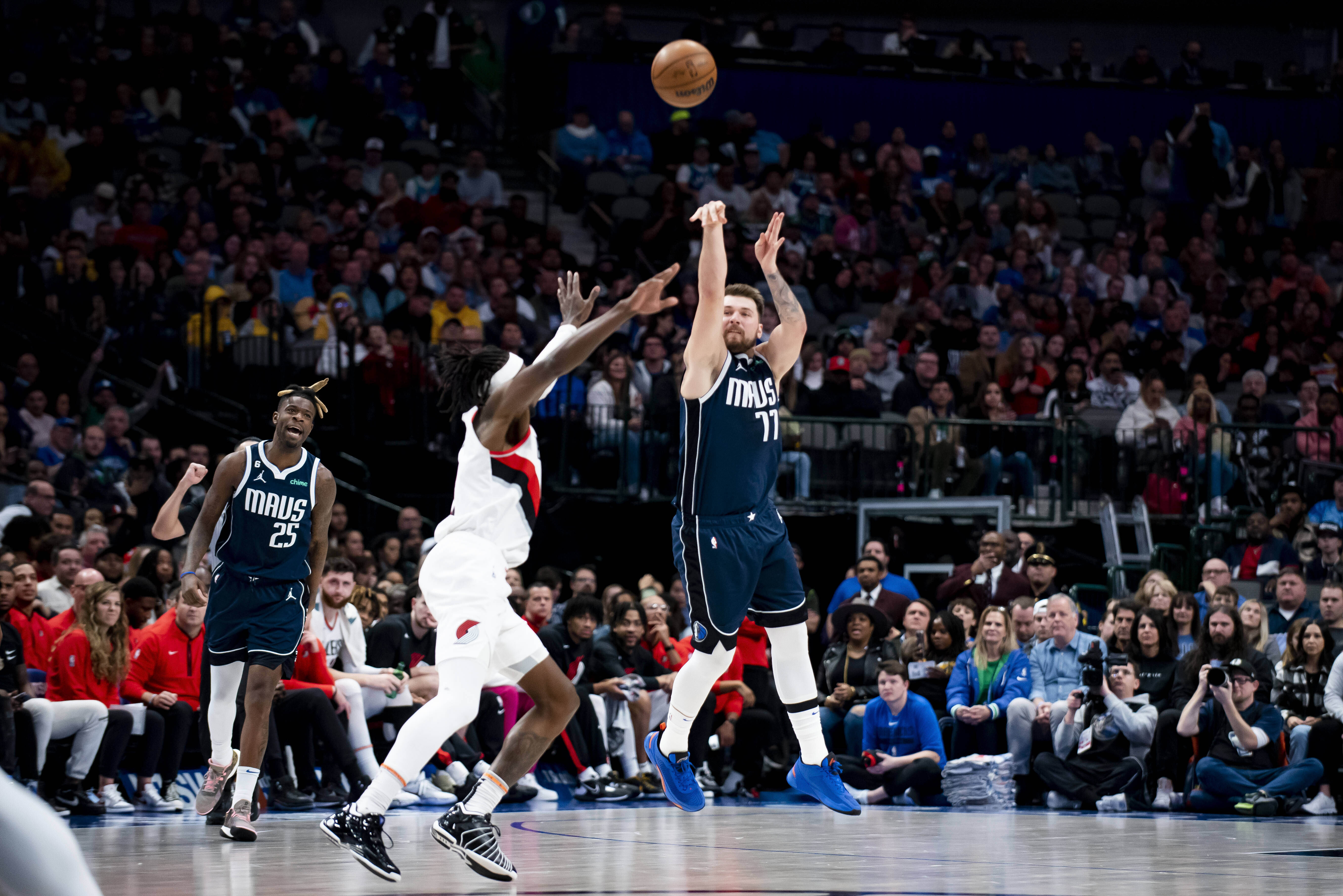 FILE - Dallas Mavericks guard Luka Doncic (77) heaves a shot from half court over Portland Trail Blazers forward Jerami Grant (9) as the buzzer sounds in the first half of an NBA basketball game in Dallas, Dec. 16, 2022. 