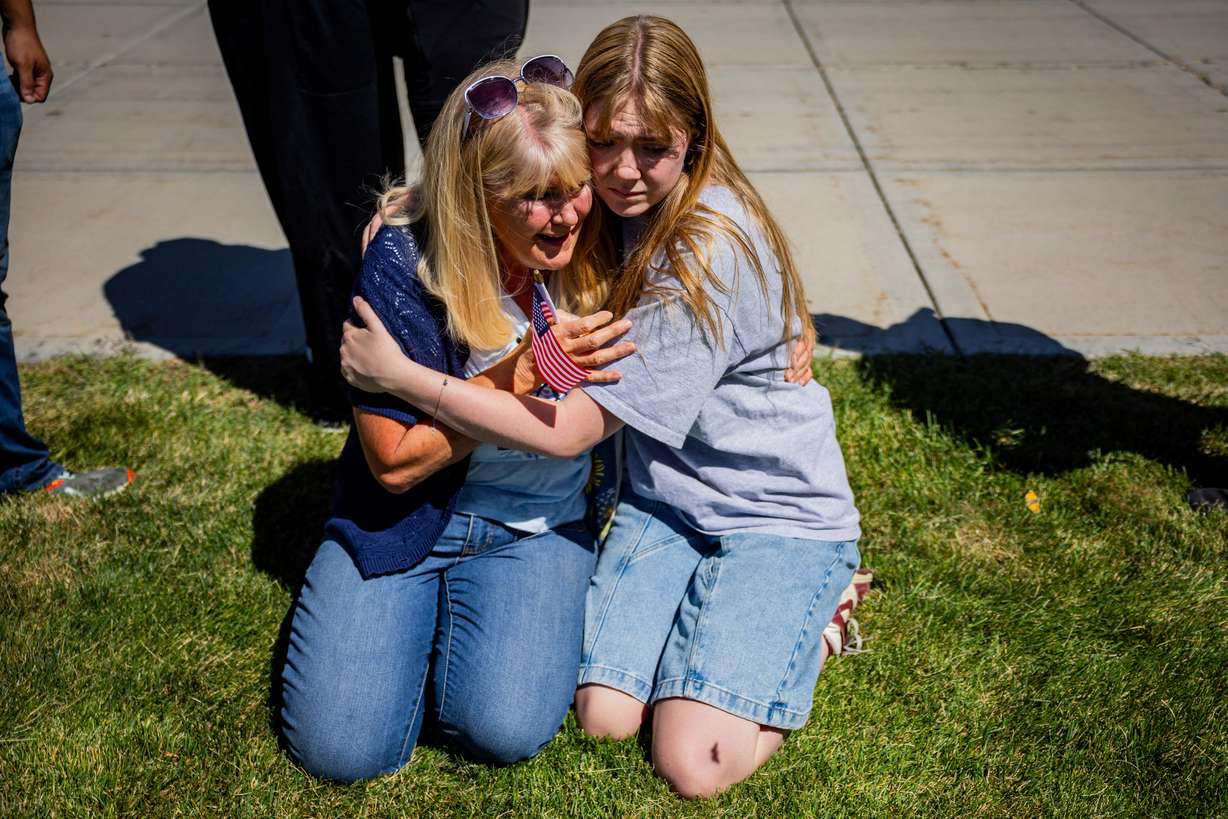 Strangers Cheryl Stout, left, and Charlotte Miller, right, comfort each other after Charlie Kirk is shot during Turning Point's visit to Utah Valley University in Orem on Wednesday.