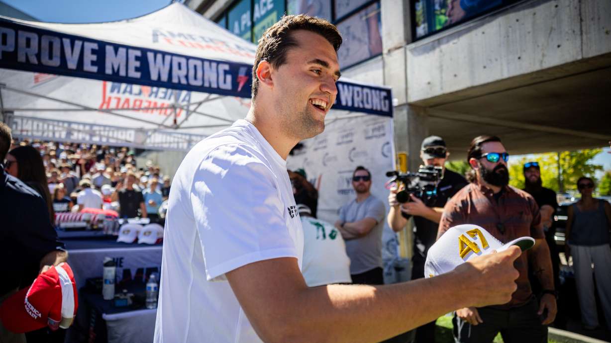 Charlie Kirk hands out hats before he was shot and killed during Turning Point USA’s visit to Utah Valley University in Orem on Wednesday.