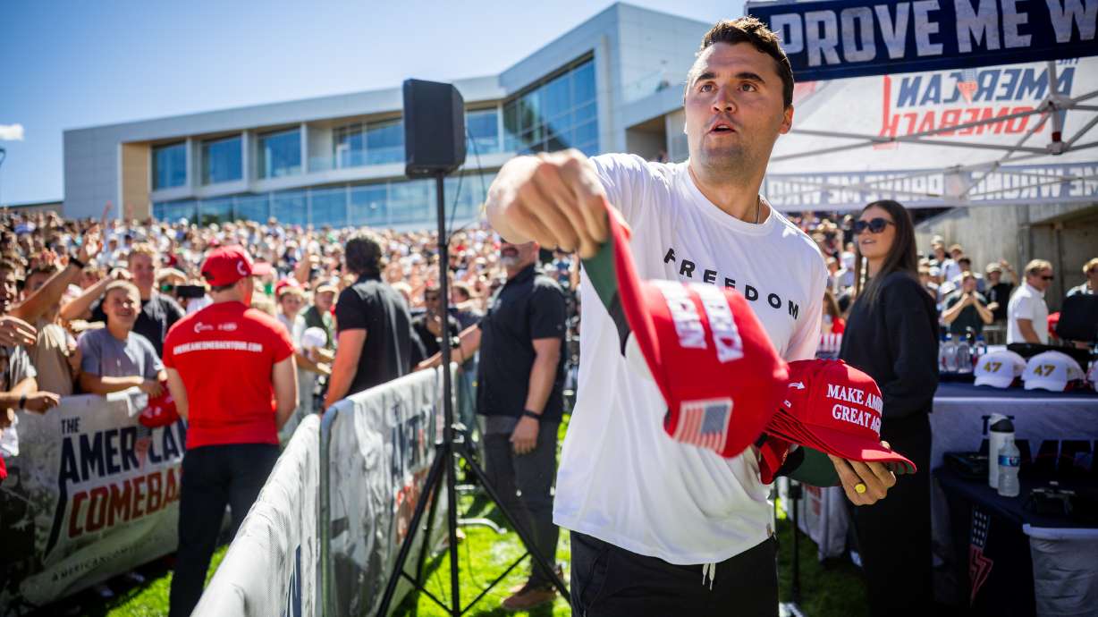 Charlie Kirk hands out hats before he was shot during Turning Point USA’s visit to Utah Valley University in Orem on Sept. 10, 2025. His estate has filed notice against UVU that they intend to file a lawsuit against the school.