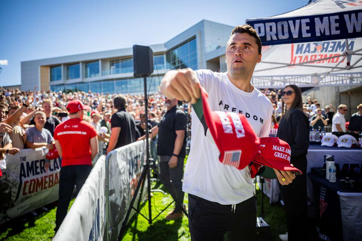 Charlie Kirk hands out hats before he was shot during Turning Point USA’s visit to Utah Valley University in Orem on Wednesday.