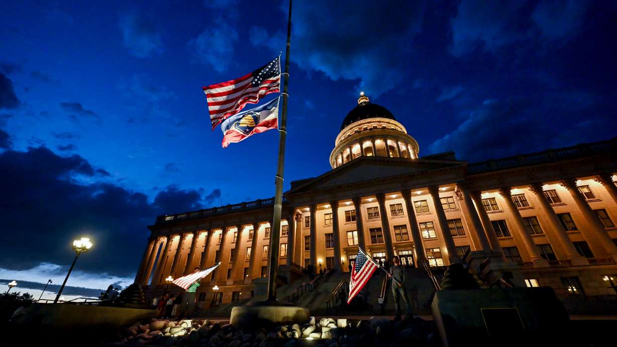 Thomas Hess and Nolan Jenson stand in front of the Capitol with flags after members of the community gathered in Salt Lake City in honor of Charlie Kirk, who was shot at Utah Valley University and died at a local hospital on Wednesday.