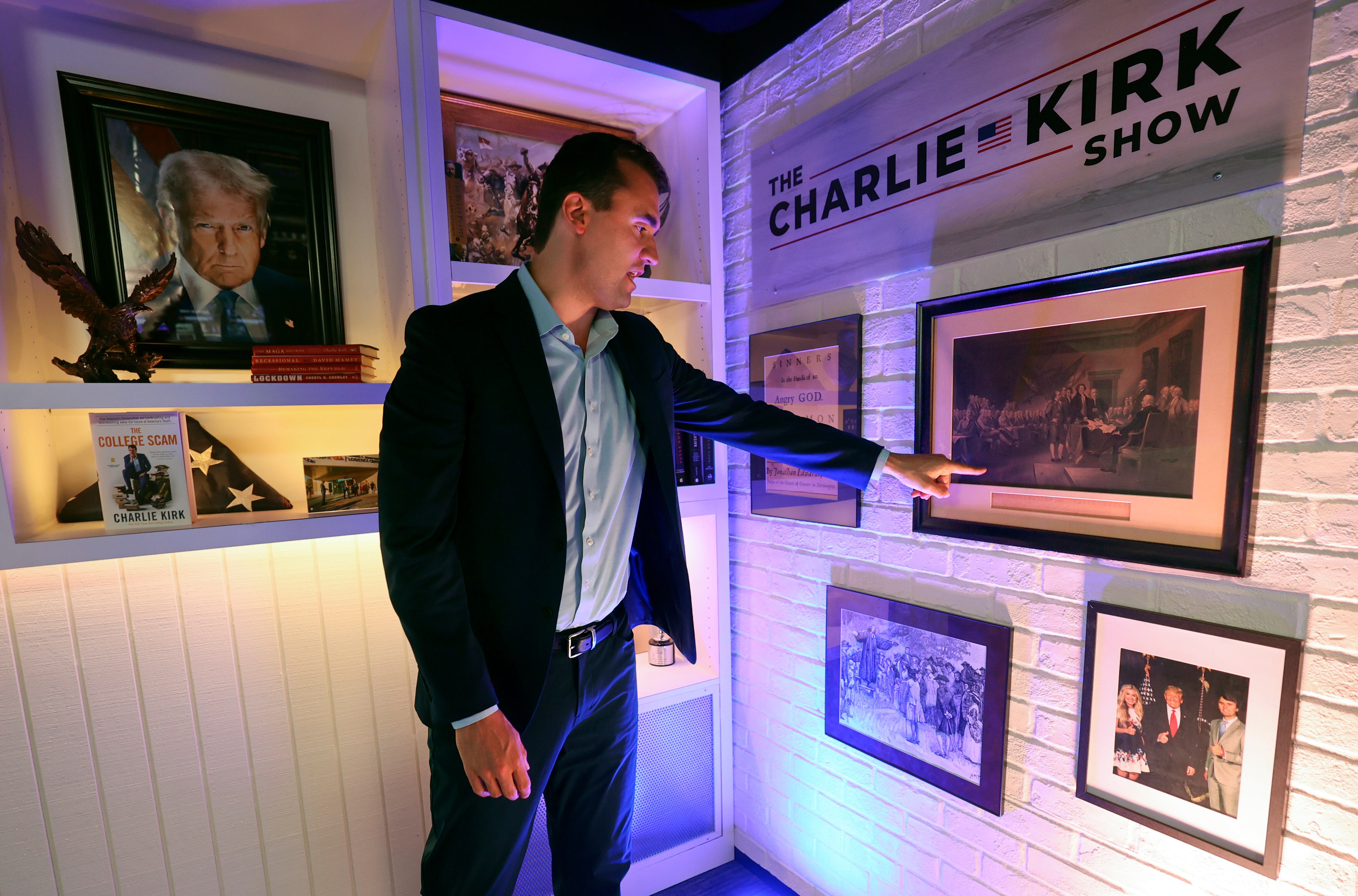 Charlie Kirk, Turning Point USA founder and president, shows a painting from the early 1800s of the signing of the Declaration of Independence that is hanging on the set of "The Charlie Kirk Show" at Turning Point headquarters in Phoenix, Ariz., on Aug. 19. The painting was gifted to him.