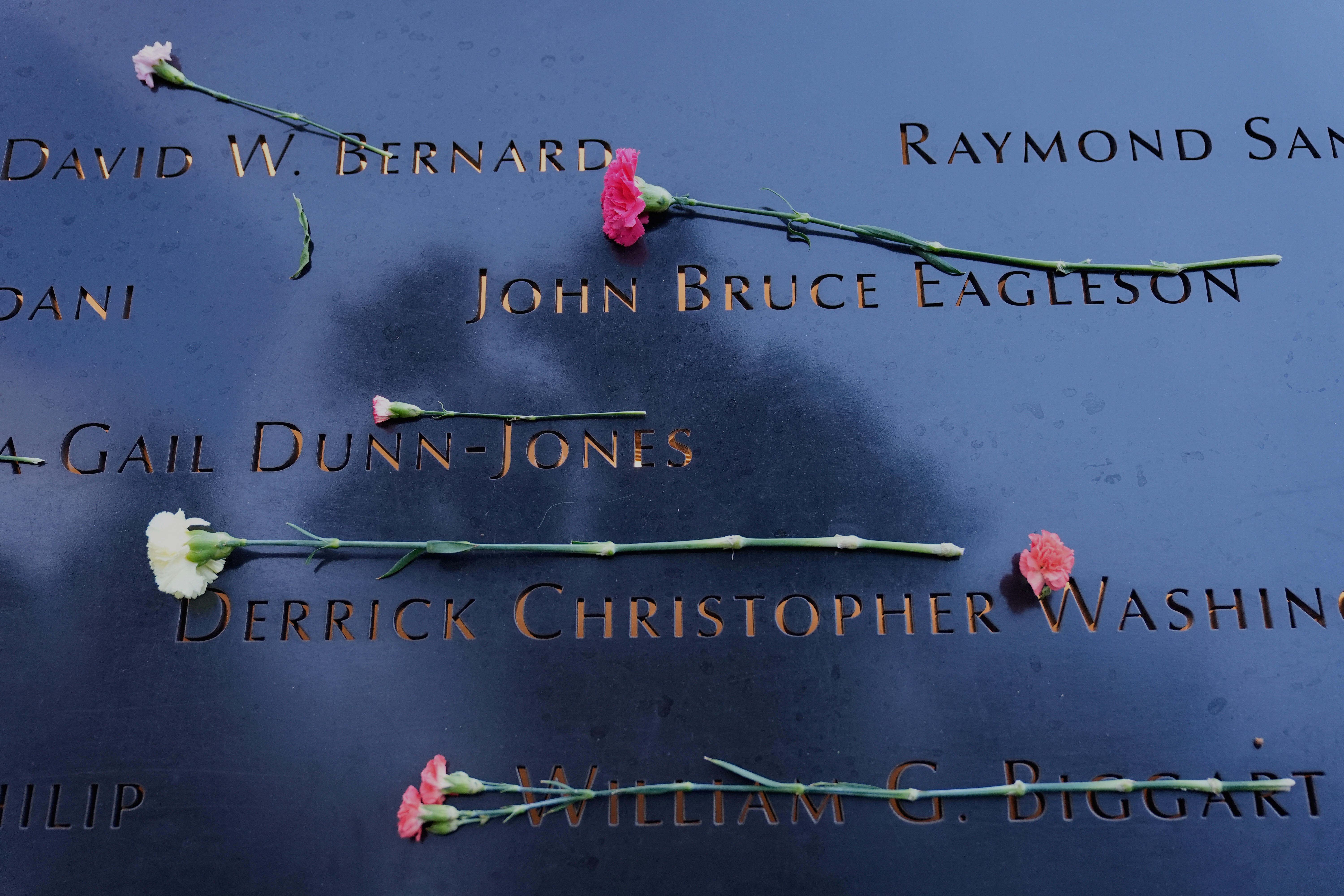Flowers lay on names inscribed at the 9/11 Memorial before the start of a ceremony commemorating the 24th anniversary of the Sept. 11, 2001, attacks, Thursday, in New York.