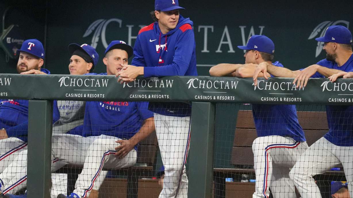 Texas Rangers pitcher Jacob deGrom, standing, is seen in the dugout with teammates prior to a baseball game against the Milwaukee Brewers Wednesday, Sept. 10, 2025, in Arlington, Texas.