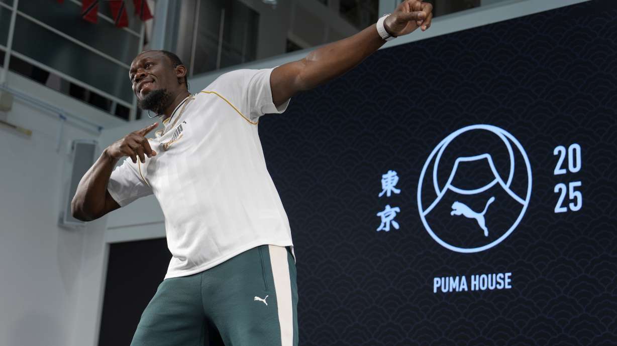 Former sprinter, Jamaica's Usain Bolt makes his signature pose at the end of a press conference ahead of the World Athletics Championships in Tokyo, Japan, Thursday, Sept. 11, 2025.