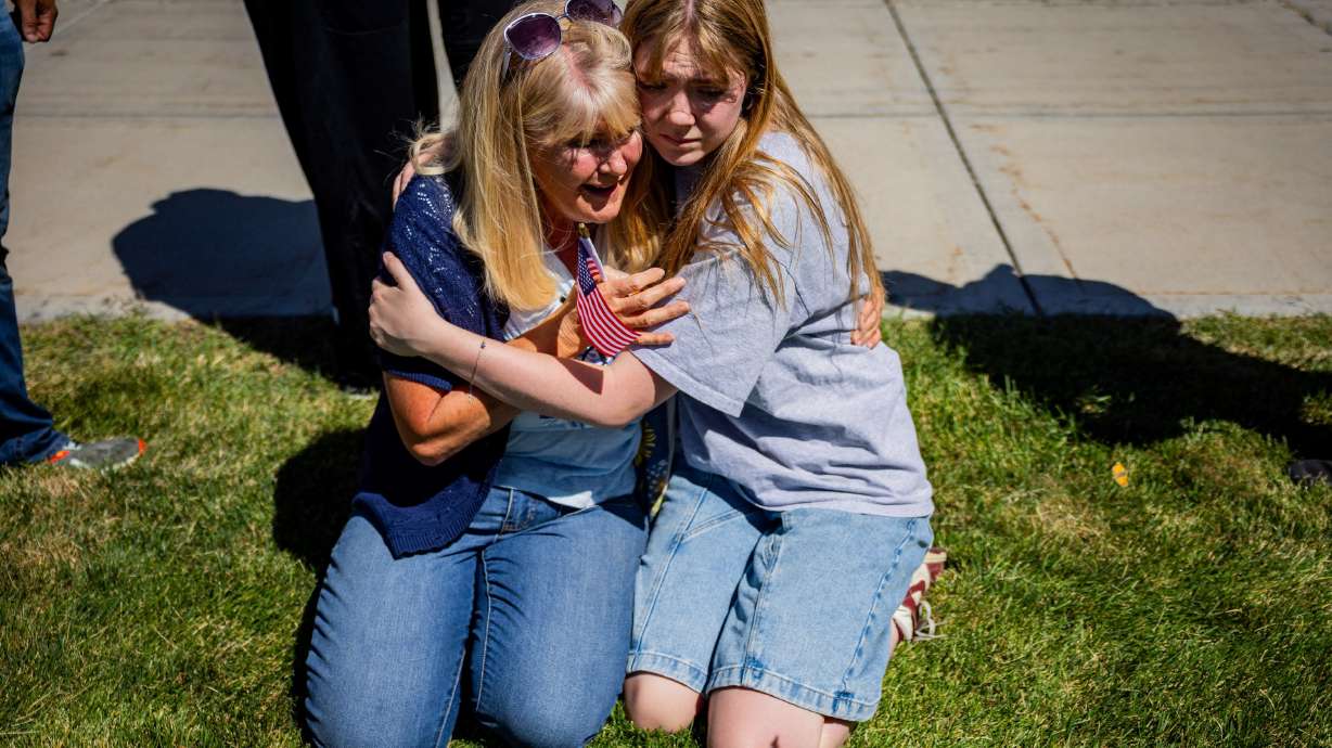 Strangers Cheryl Stout, left, and Charlotte Miller, right, comfort each other after Charlie Kirk was shot during Turning Point USA’s visit to Utah Valley University in Orem on Wednesday.