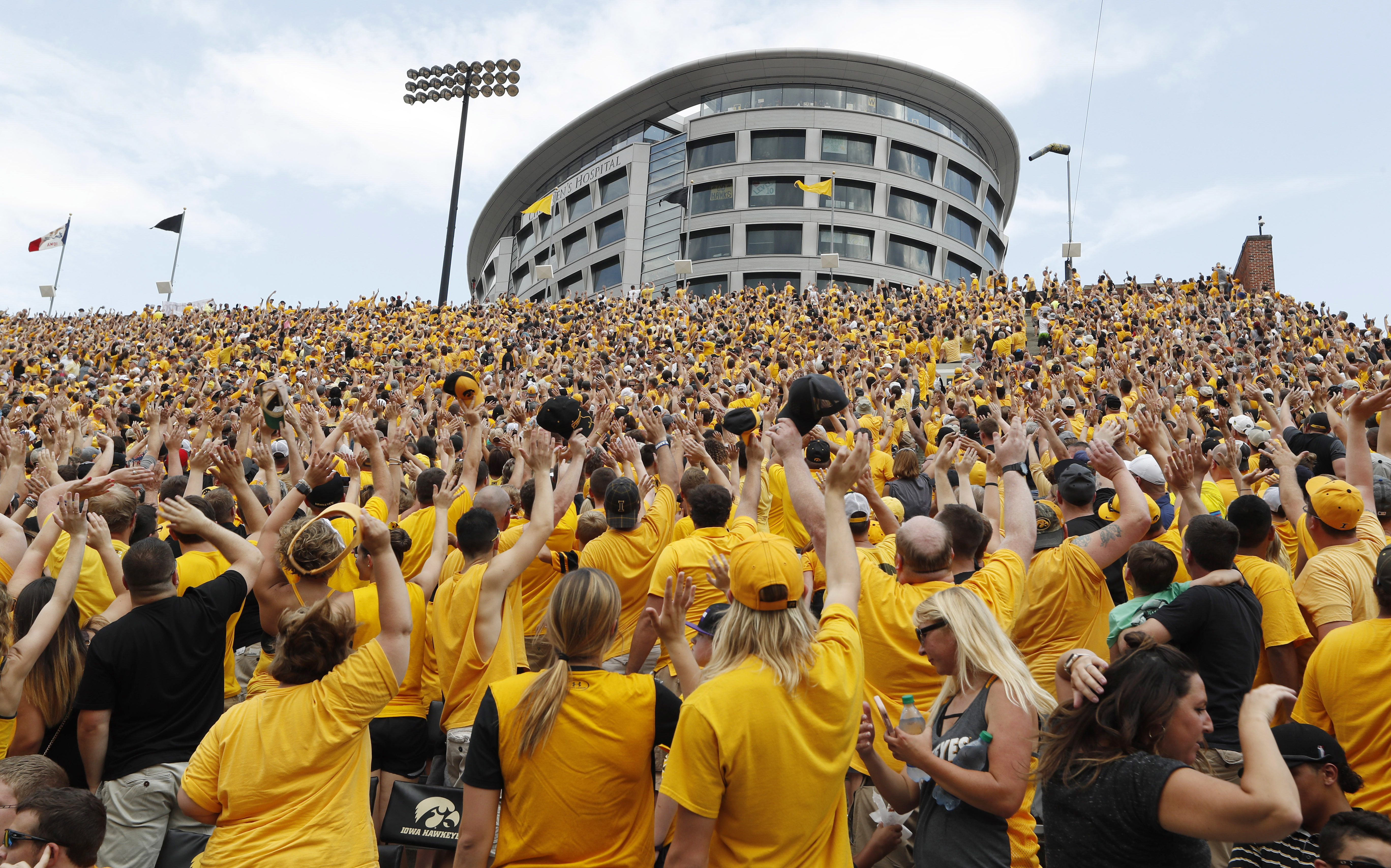 FILE - Iowa fans wave to children in the University of Iowa Stead Family Children's Hospital at the end of the first quarter of an NCAA college football game against North Texas, Sept. 16, 2017, in Iowa City, Iowa. 