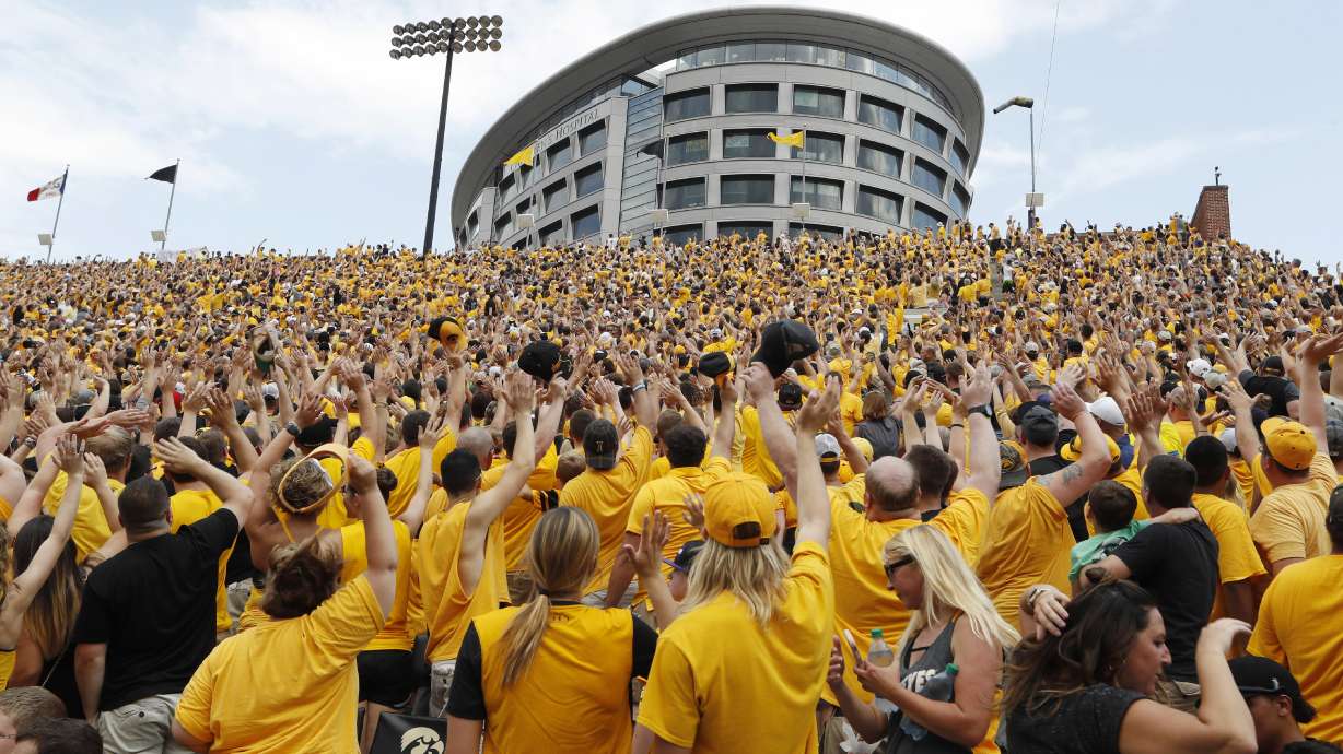 FILE - Iowa fans wave to children in the University of Iowa Stead Family Children's Hospital at the end of the first quarter of an NCAA college football game against North Texas, Sept. 16, 2017, in Iowa City, Iowa.