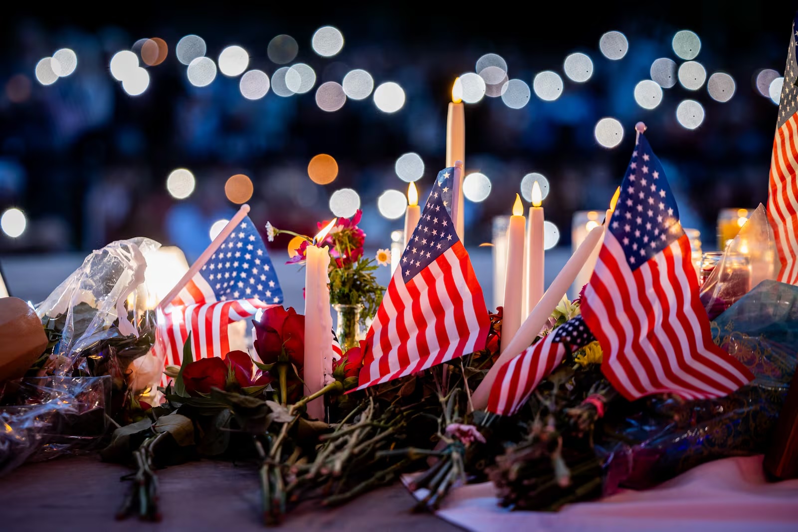 People leave candles, flowers and American flags beneath a photo of Charlie Kirk at a vigil at City Center Park in Orem on Thursday, Sept. 11. Charlie Kirk, the CEO and co-founder of the conservative youth organization Turning Point USA, was fatally shot during Turning Point’s visit to Utah Valley University on Wednesday.