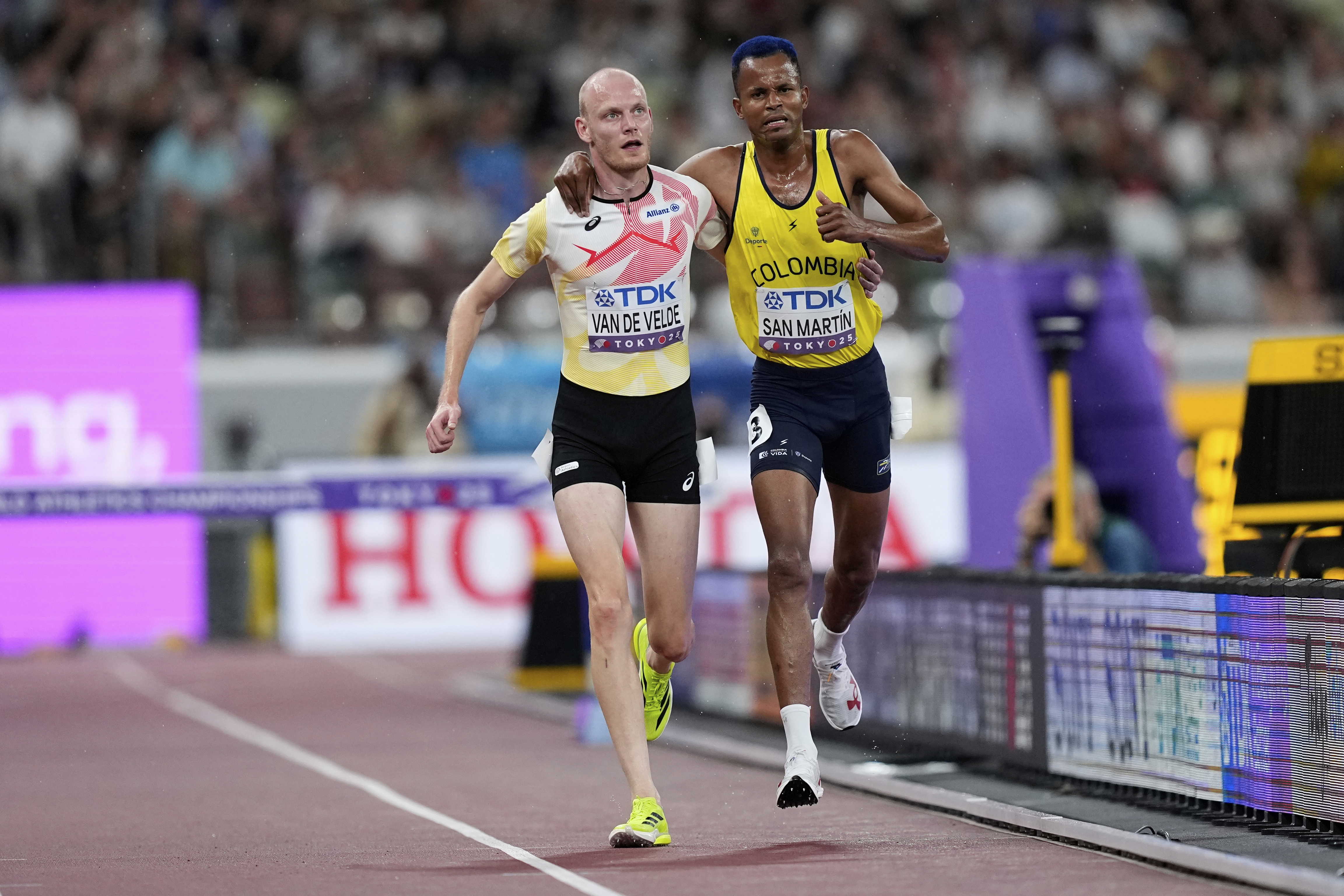 Colombia's Carlos San Martin and Belgium's Tim Van De Velde help each other to the nine during a men's 3,000 meters steeplechase heat at the World Athletics Championships in Tokyo, Saturday, Sept. 13, 2025. 