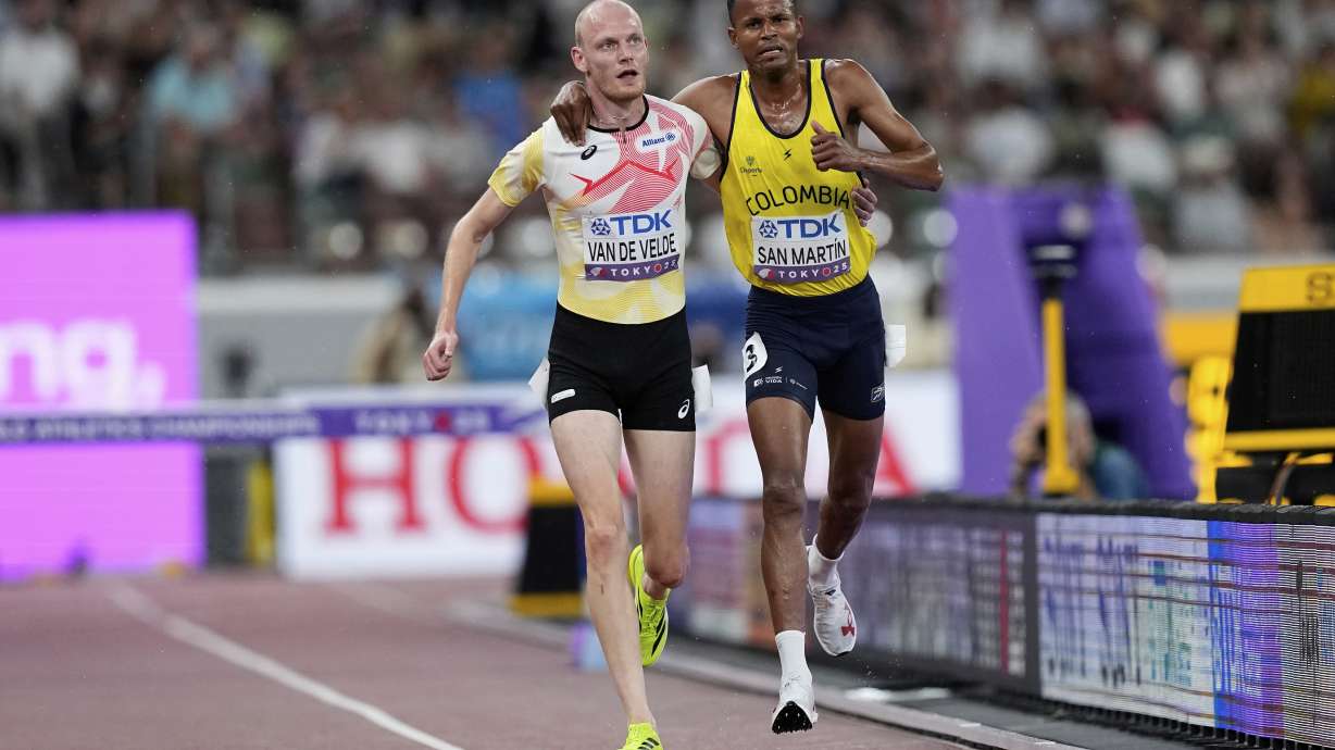 Colombia's Carlos San Martin and Belgium's Tim Van De Velde help each other to the nine during a men's 3,000 meters steeplechase heat at the World Athletics Championships in Tokyo, Saturday, Sept. 13, 2025.