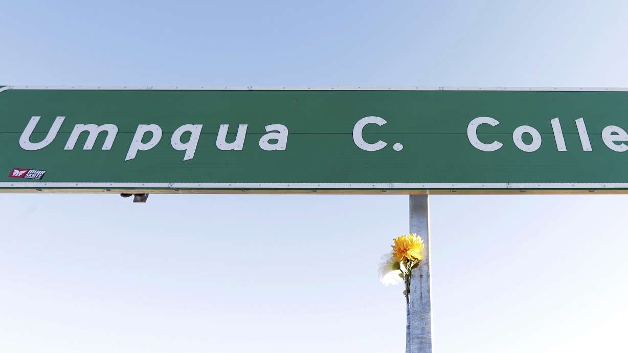 FILE - A flower is posted on a direction sign to Umpqua Community College, Oct. 2, 2015, in Roseburg, Ore.