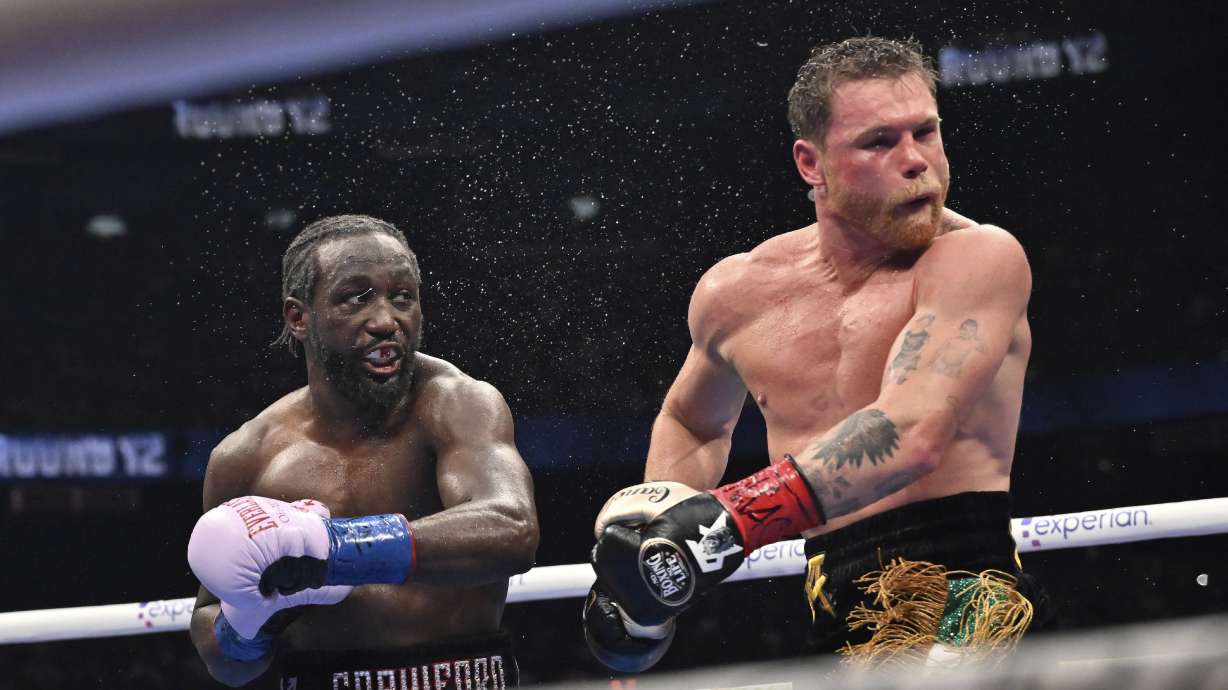 Terence Crawford, left, punches Canelo Alvarez during an undisputed super middleweight championship boxing match in Las Vegas, Saturday, Sept. 13, 2025.