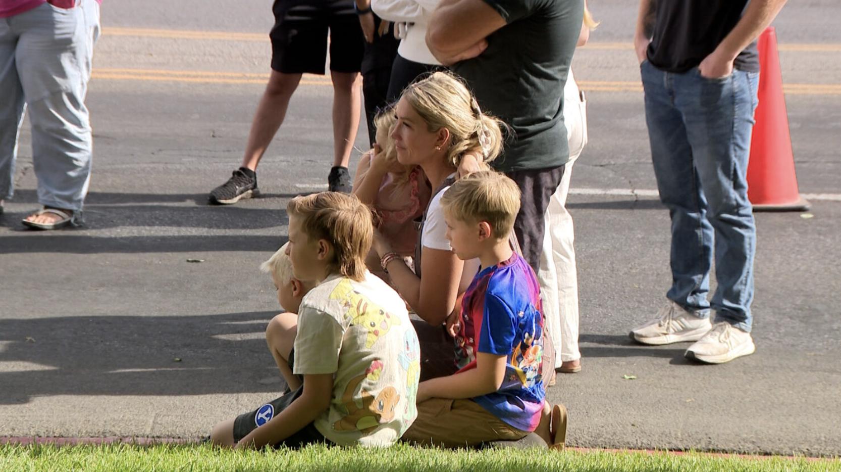 Kelly Cahoon looks at a memorial honoring Charlie Kirk with her children on the campus of Utah Valley University, Saturday.