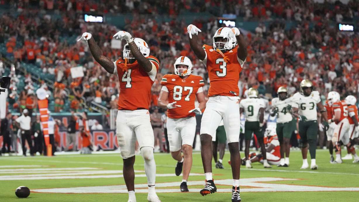 Miami Hurricanes running back Mark Fletcher Jr. (4) celebrates with Miami Hurricanes wide receiver Joshua Moore (3) after scoring a touchdown during the second half of an NCAA college football game against South Florida, Saturday, Sept. 13, 2025, in Miami Gardens, Fla.