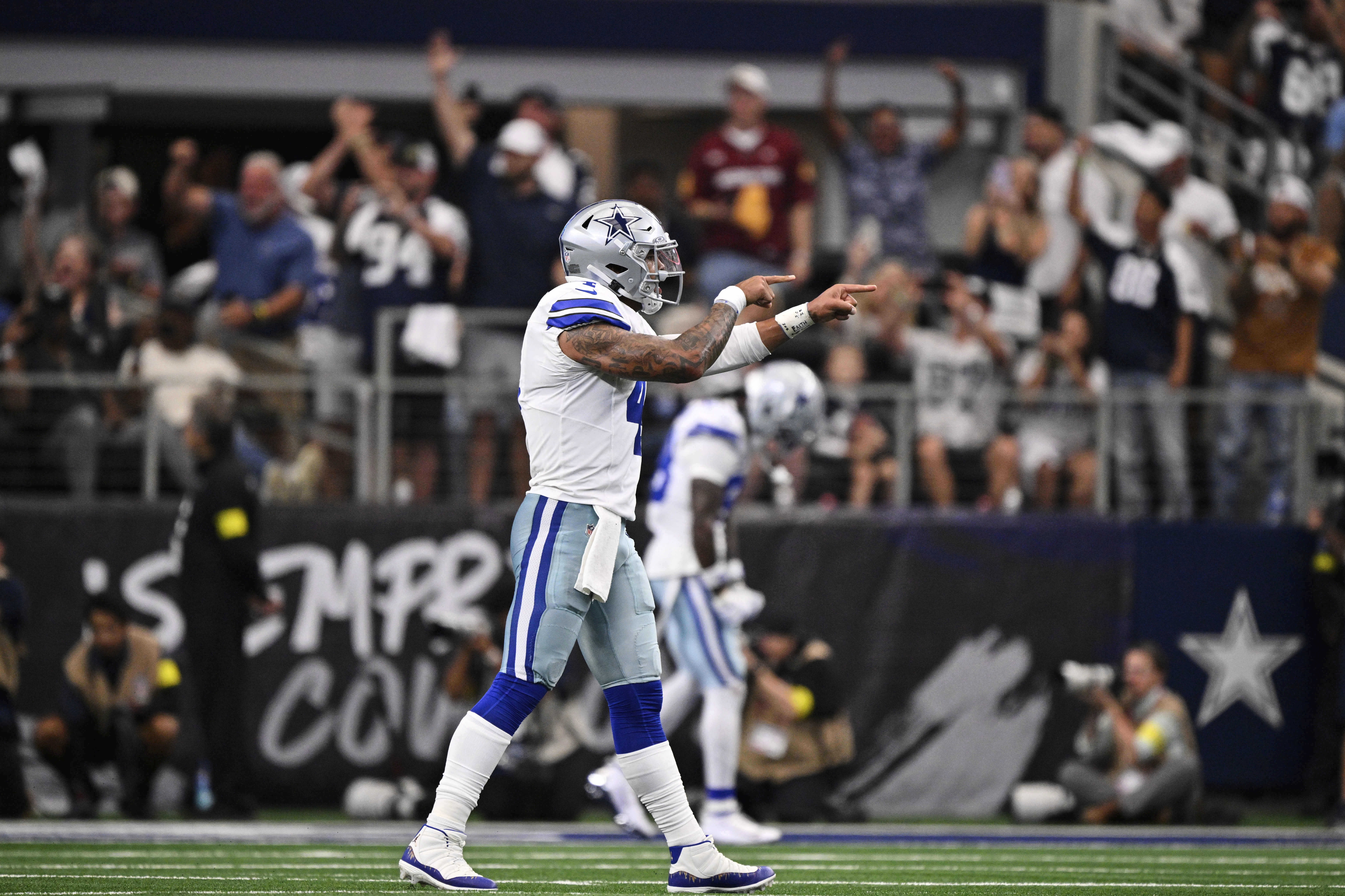 Dallas Cowboys quarterback Dak Prescott (4) celebrates a touchdown late in the second half of an NFL football game against the New York Giants Sunday, Sept. 14, 2025, in Arlington, Texas.