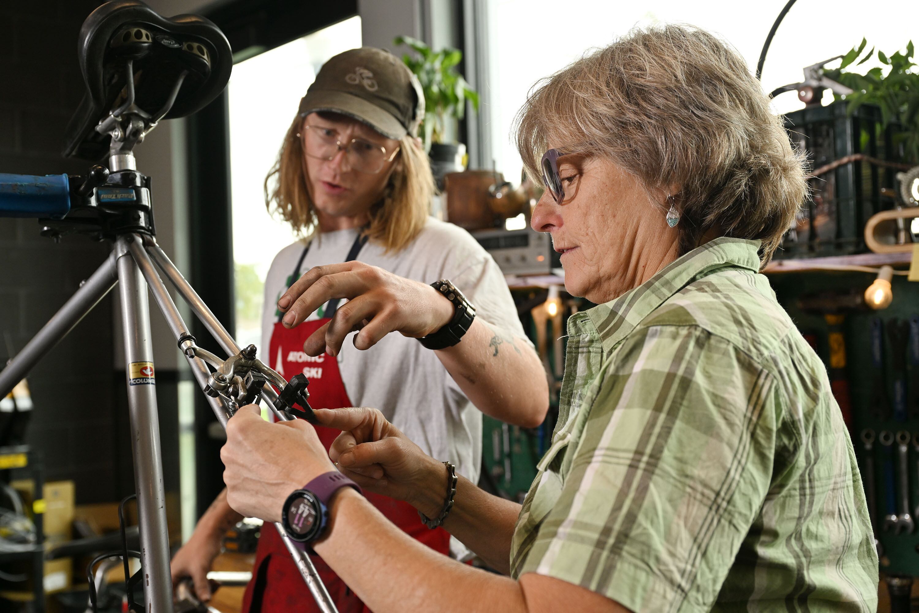 Donna McAleer, executive director of the Bike Collective, talks with mechanic Thomas Kennedy McDonagh in the pro shop at the business in Salt Lake City on Aug. 26.