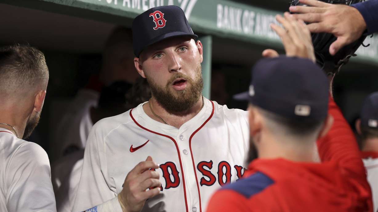 Boston Red Sox pitcher Garrett Crochet is congratulated in the dugout after the seventh inning of a baseball game against the New York Yankees, Sunday, Sept. 14, 2025, in Boston.