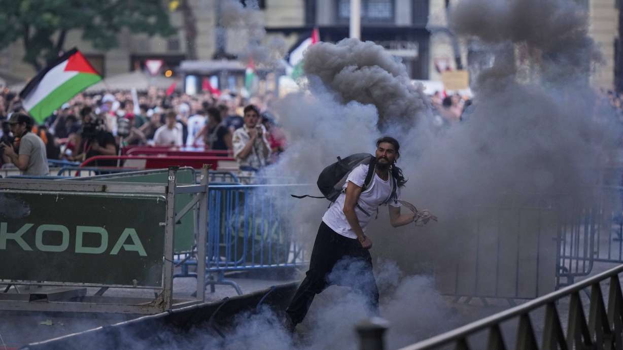 Protesters clash with police as they block the road trying to disrupt the twenty-first stage of the Spanish cycling race La Vuelta, from Alalpardo to Madrid, Spain, Sunday, Sept. 14, 2025.