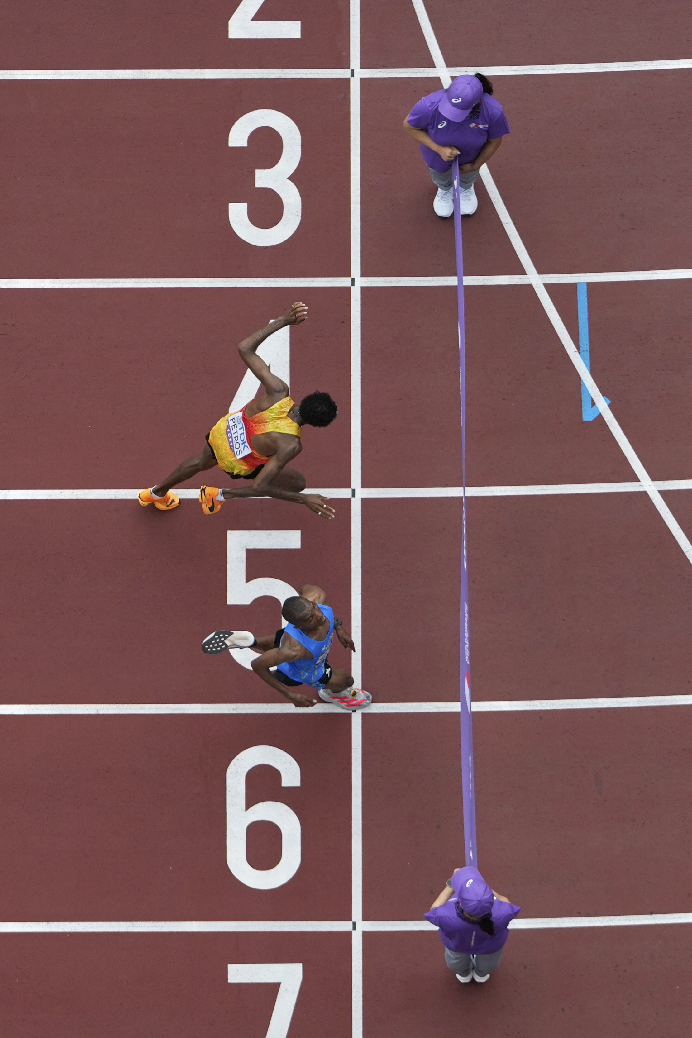 Tanzania's Alphonce Felix Simbu, bottom, crosses the finish line ahead of Germany's Amanal Petros to win the men's marathon at the World Athletics Championships in Tokyo, Monday, Sept. 15, 2025. 