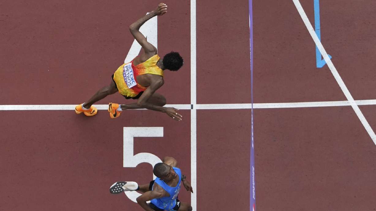 Tanzania's Alphonce Felix Simbu, bottom, crosses the finish line ahead of Germany's Amanal Petros to win the men's marathon at the World Athletics Championships in Tokyo, Monday, Sept. 15, 2025.