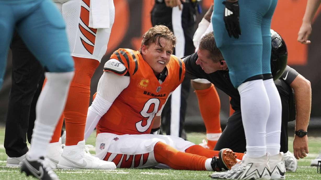 Cincinnati Bengals quarterback Joe Burrow (9) grimaces aft being sacked by Jacksonville Jaguars defensive tackle Arik Armstead (91) during the first half of an NFL football game, Sunday, Sept. 14, 2025, in Cincinnati.