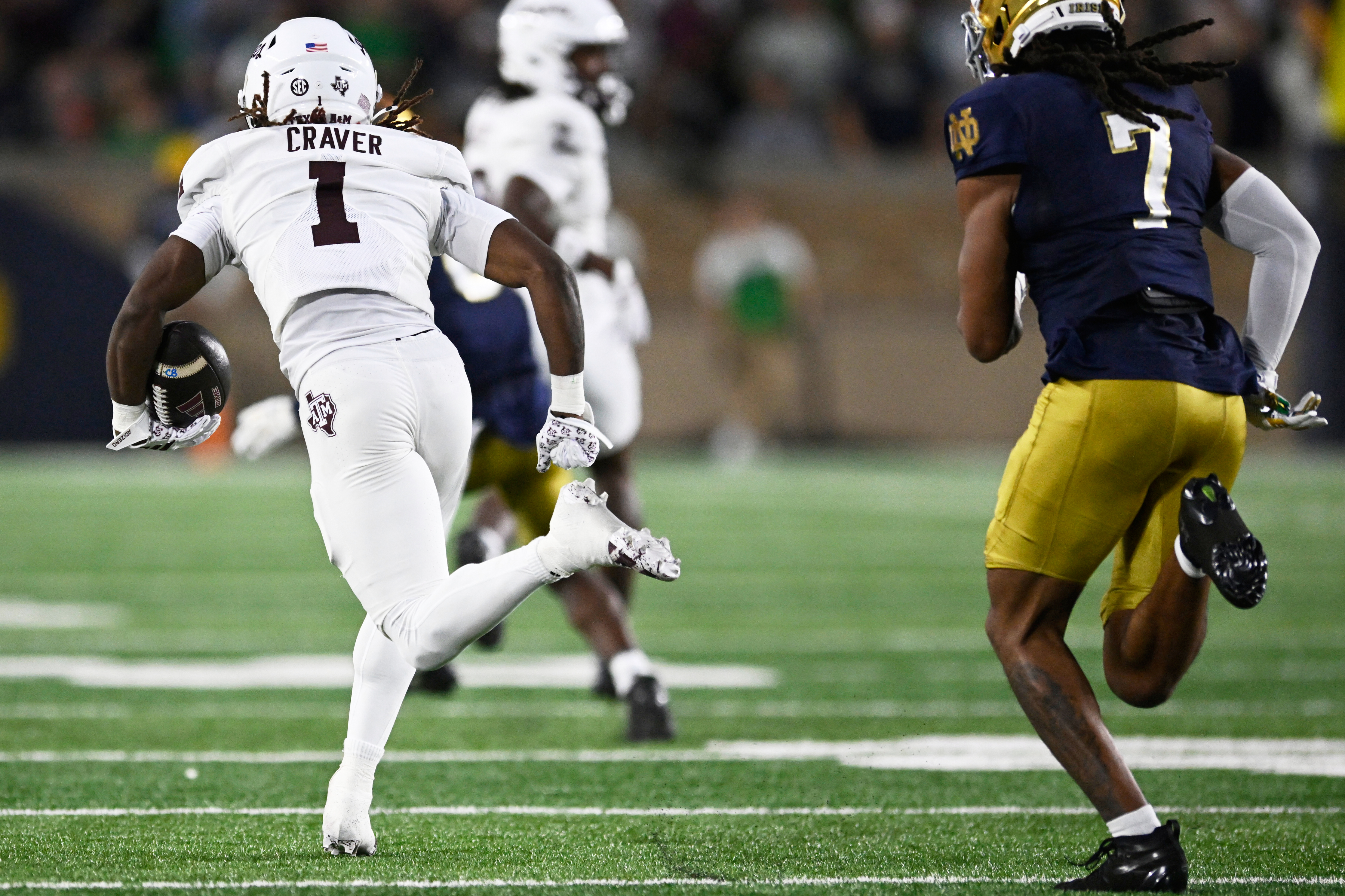 Texas A&M wide receiver Mario Craver (1) rushes for a 86 yard touchdown after catching a pass against Notre Dame's Ty Washington (7) during the first half of an NCAA football game Saturday, Sept. 13, 2025, in South Bend, Ind. 