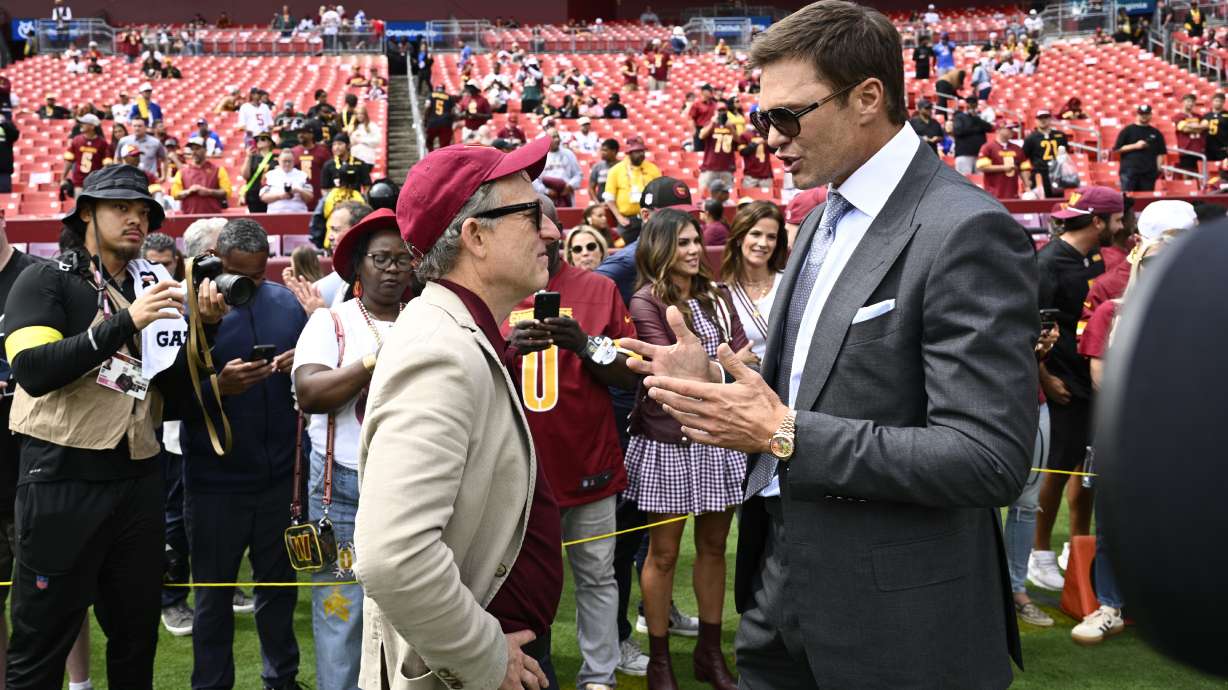 Washington Commanders owenr Josh Harris, right, talks with former NFL quarterback Tom Brady, right, before the start of an NFL football game against the New York Giants, Sunday, Sept. 7, 2025, in Landover, Md.