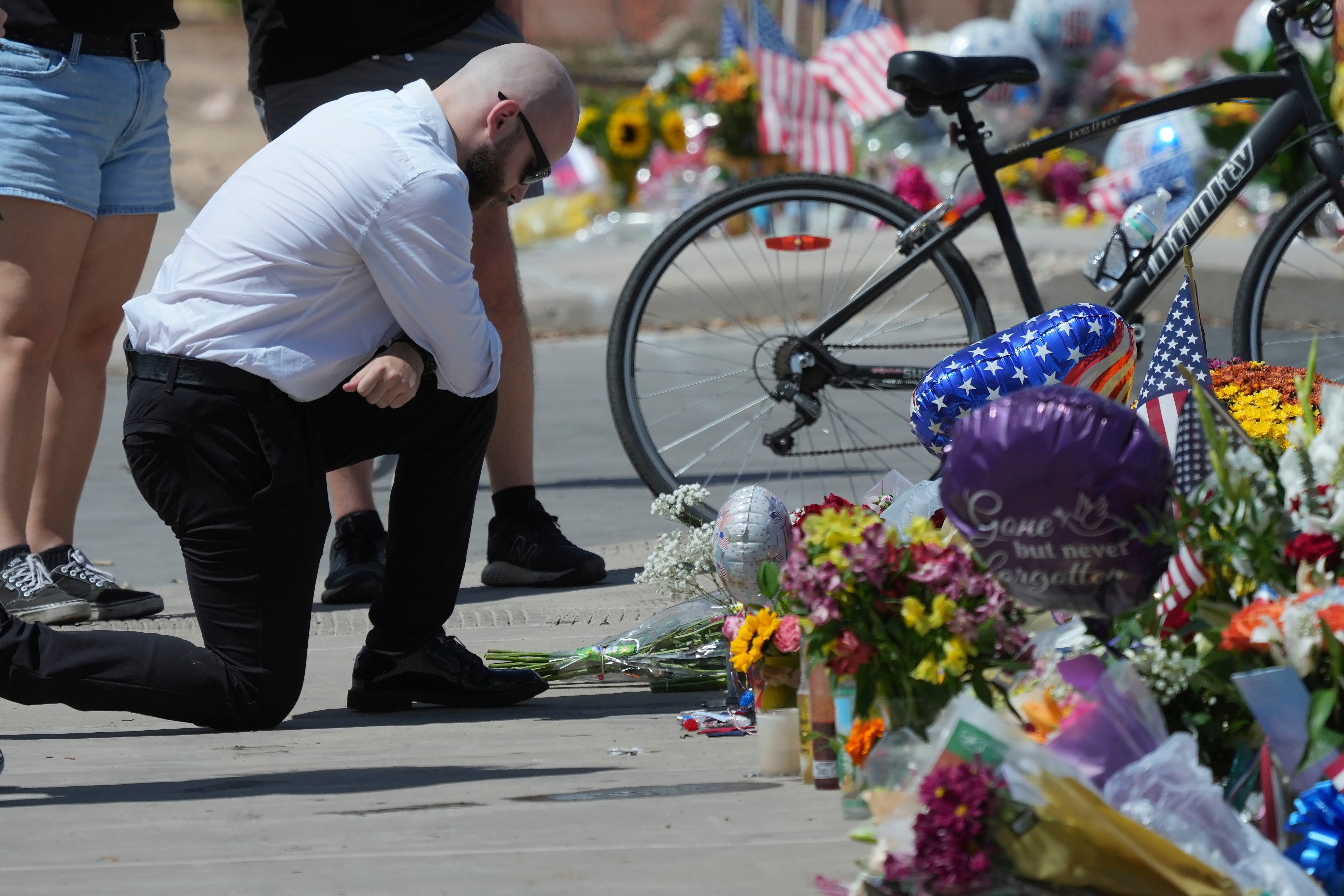 A well-wisher prays at a makeshift memorial set up at Turning Point USA headquarters after the shooting death at a Utah college on Wednesday of Charlie Kirk, the co-founder and CEO of the organization, Thursday in Phoenix.