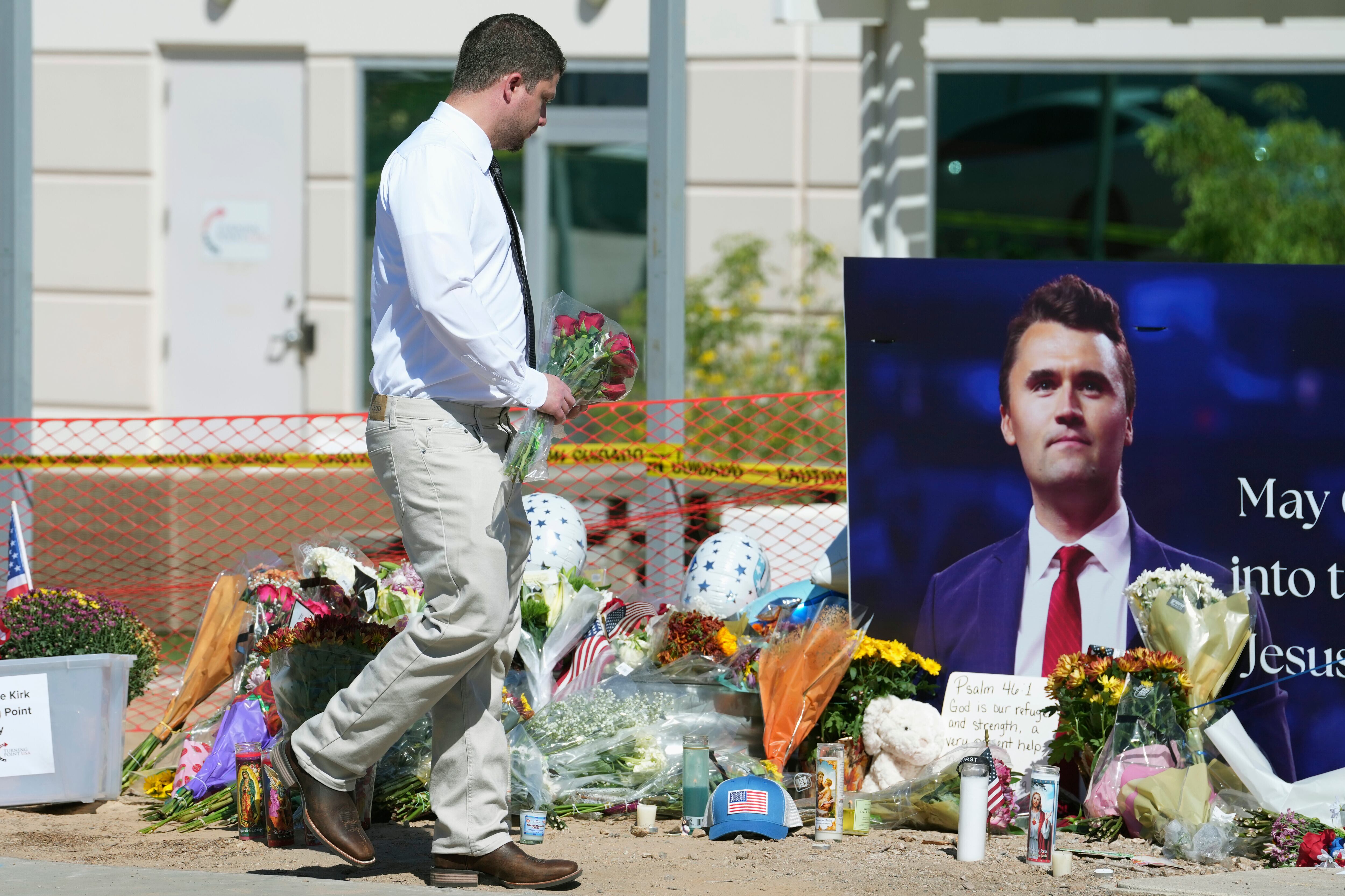 A well-wisher adds flowers to a makeshift memorial set up at Turning Point USA headquarters after the shooting death at a Utah college on Wednesday of Charlie Kirk, the 31-year-old founder and CEO of the organization, Thursday in Phoenix.