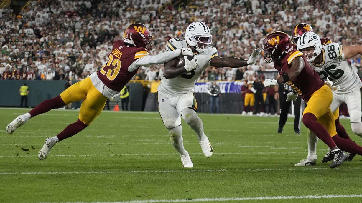 Green Bay Packers running back Josh Jacobs runs with the ball as Washington Commanders cornerback Trey Amos (23) defends during the second half of an NFL football game Thursday, Sept. 11, 2025, in Green Bay, Wis.
