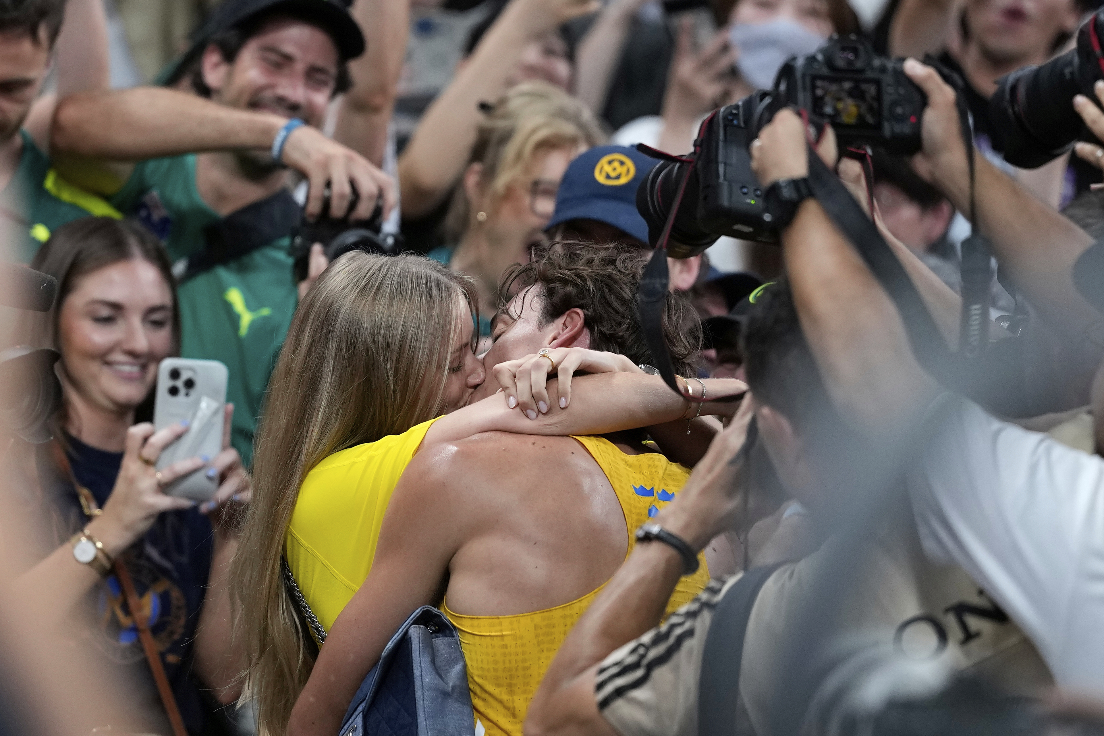 Sweden's Armand Duplantis kisses his girlfriend Desire Inglander after setting a new men's pole vault world record of 6.30 meters, at the World Athletics Championships in Tokyo, Monday, Sept. 15, 2025. 