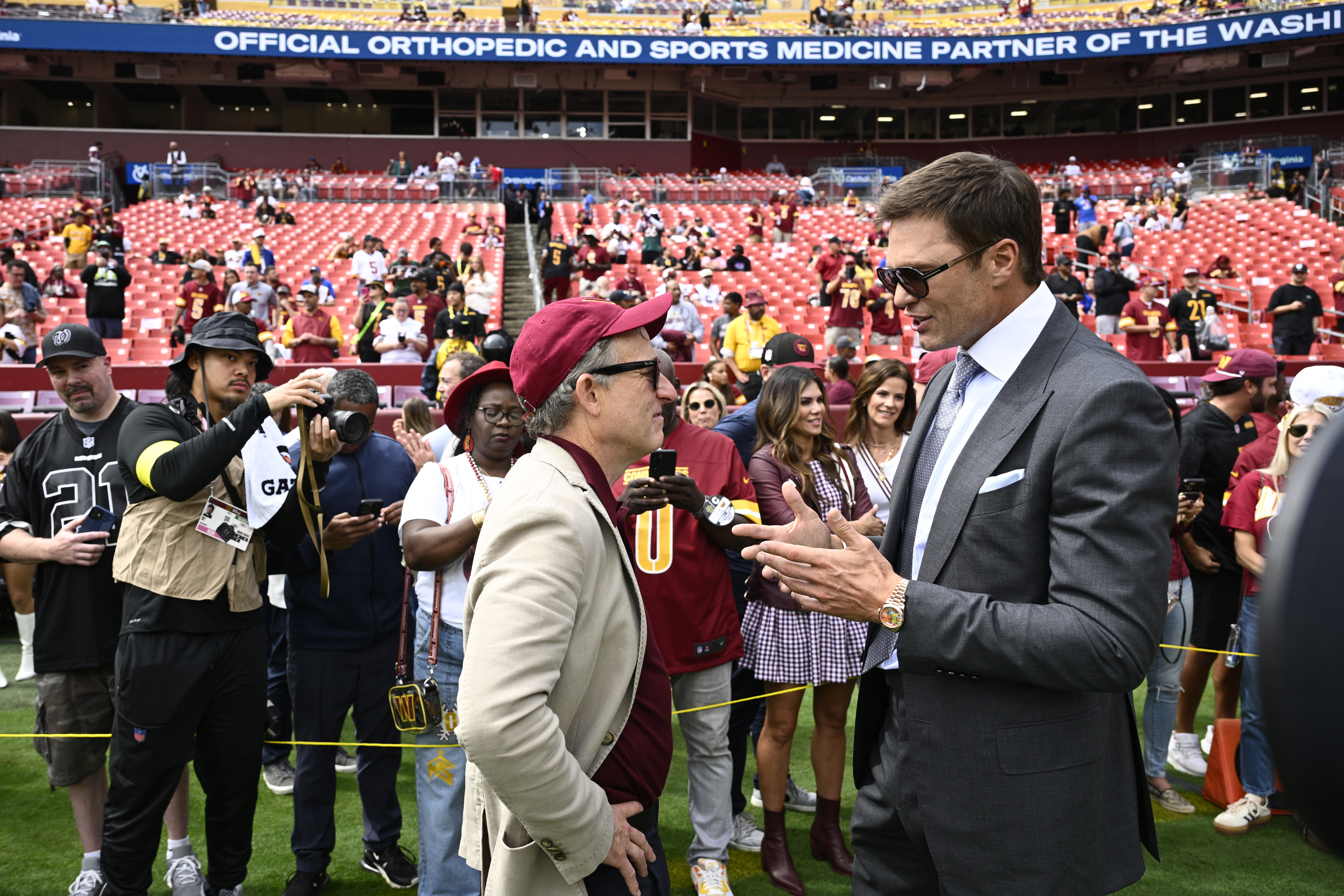 Washington Commanders owenr Josh Harris, right, talks with former NFL quarterback Tom Brady, right, before the start of an NFL football game against the New York Giants, Sunday, Sept. 7, 2025, in Landover, Md. 