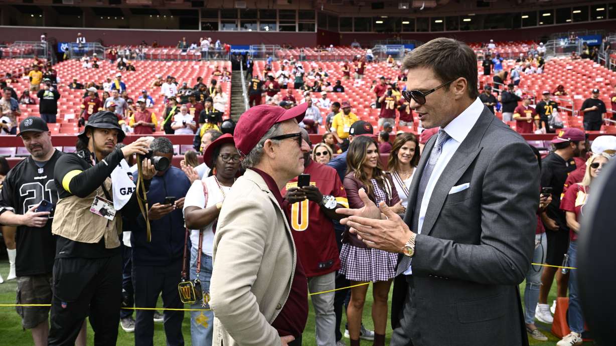Washington Commanders owenr Josh Harris, right, talks with former NFL quarterback Tom Brady, right, before the start of an NFL football game against the New York Giants, Sunday, Sept. 7, 2025, in Landover, Md.