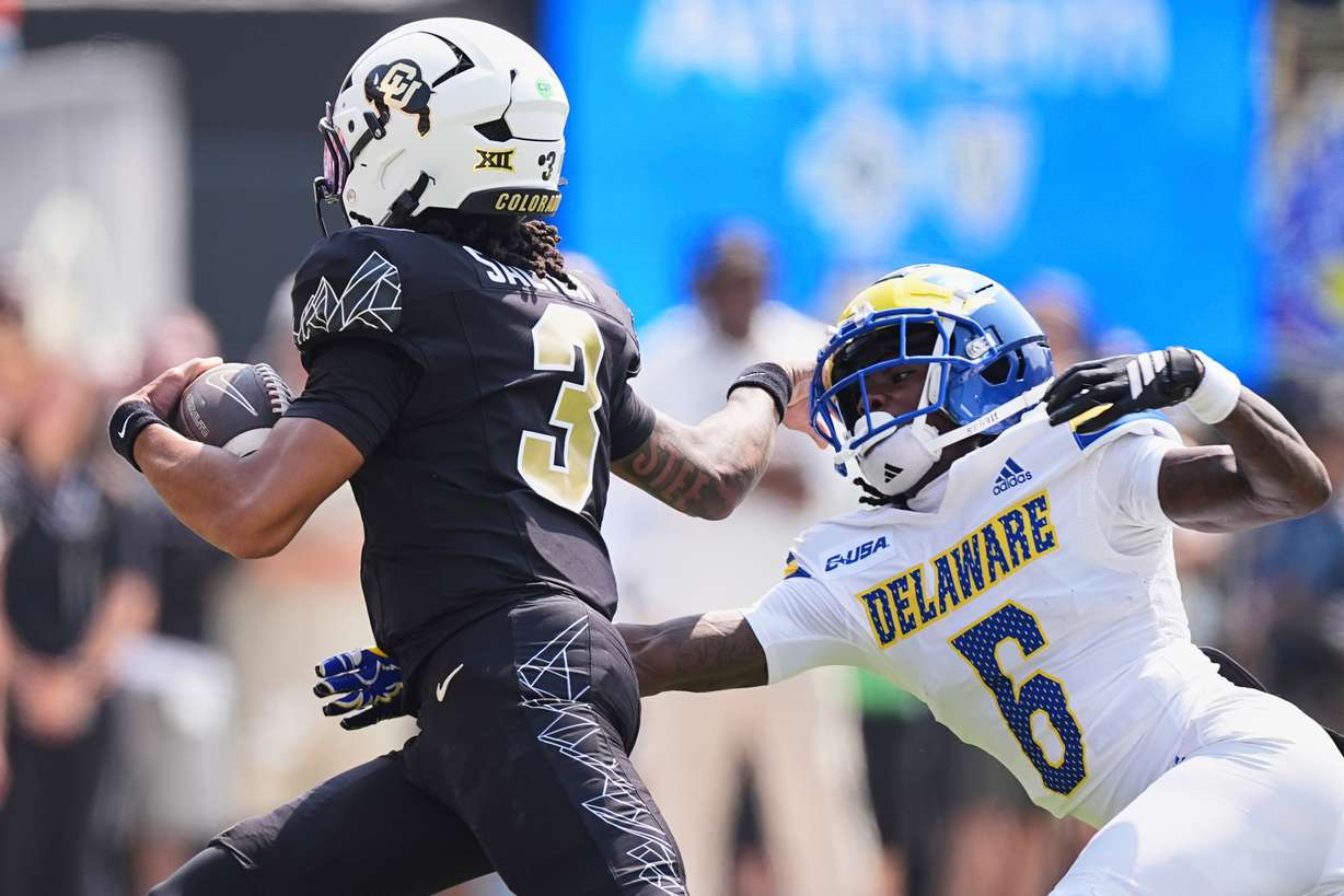 Colorado quarterback Kaidon Salter, left, eludes Delaware cornerback Kshawn Cox Jr. for a short gain in the first half of an NCAA college football game Saturday, Sept. 6, 2025, in Boulder, Colo.