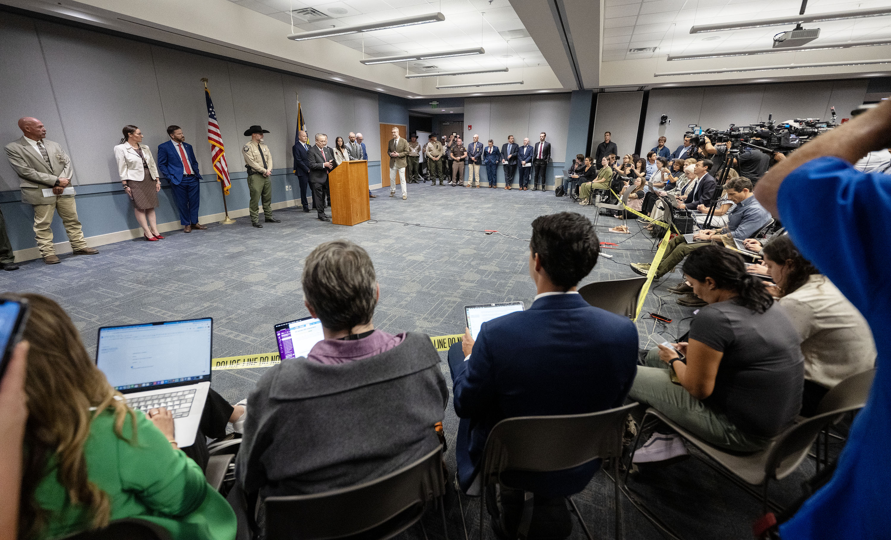 Numerous media representatives listen as Utah County Attorney Jeffrey S. Gray announces the charges his office plans to bring against Tyler Robinson, 22, who is the suspect in the shooting death of Charlie Kirk, during a press conference in Provo on Tuesday.