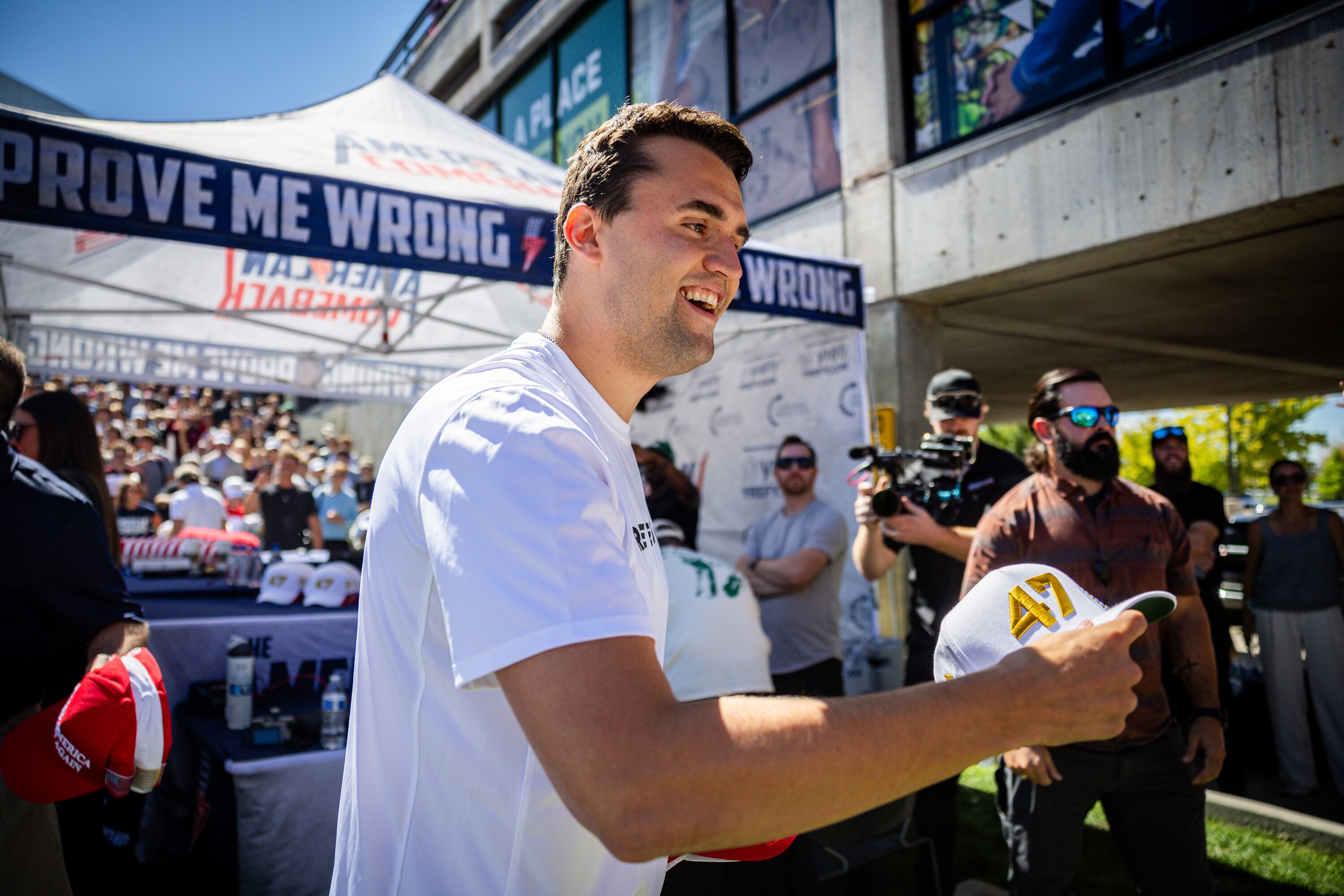 Charlie Kirk hands out hats before he was shot during Turning Point USA’s visit to Utah Valley University in Orem on Wednesday.