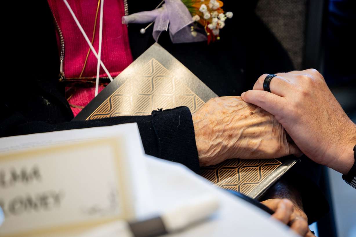 Gov. Spencer Cox holds hands with Alma DeLoney at the 37th annual Utah’s Club Centenarians celebration in West Jordan on Tuesday. Cox said each of the centenarians had a role in building the state's history.